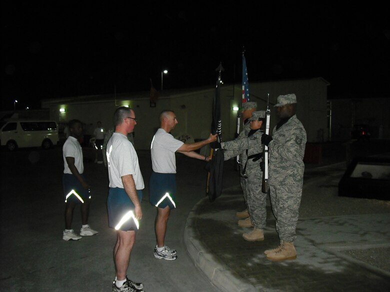 SOUTHWEST ASIA --  The 380th Air Expeditionary Wing Honor Guard ceremoniously removed the POW/MIA flag from the 9/11 Memorial here and handed it to the first runner, Master Sgt. Duane Allen from the 380th Expeditionary Security Forces Squadron to start the Memorial Run.(Photo by Capt. Ryan Harris/Released)