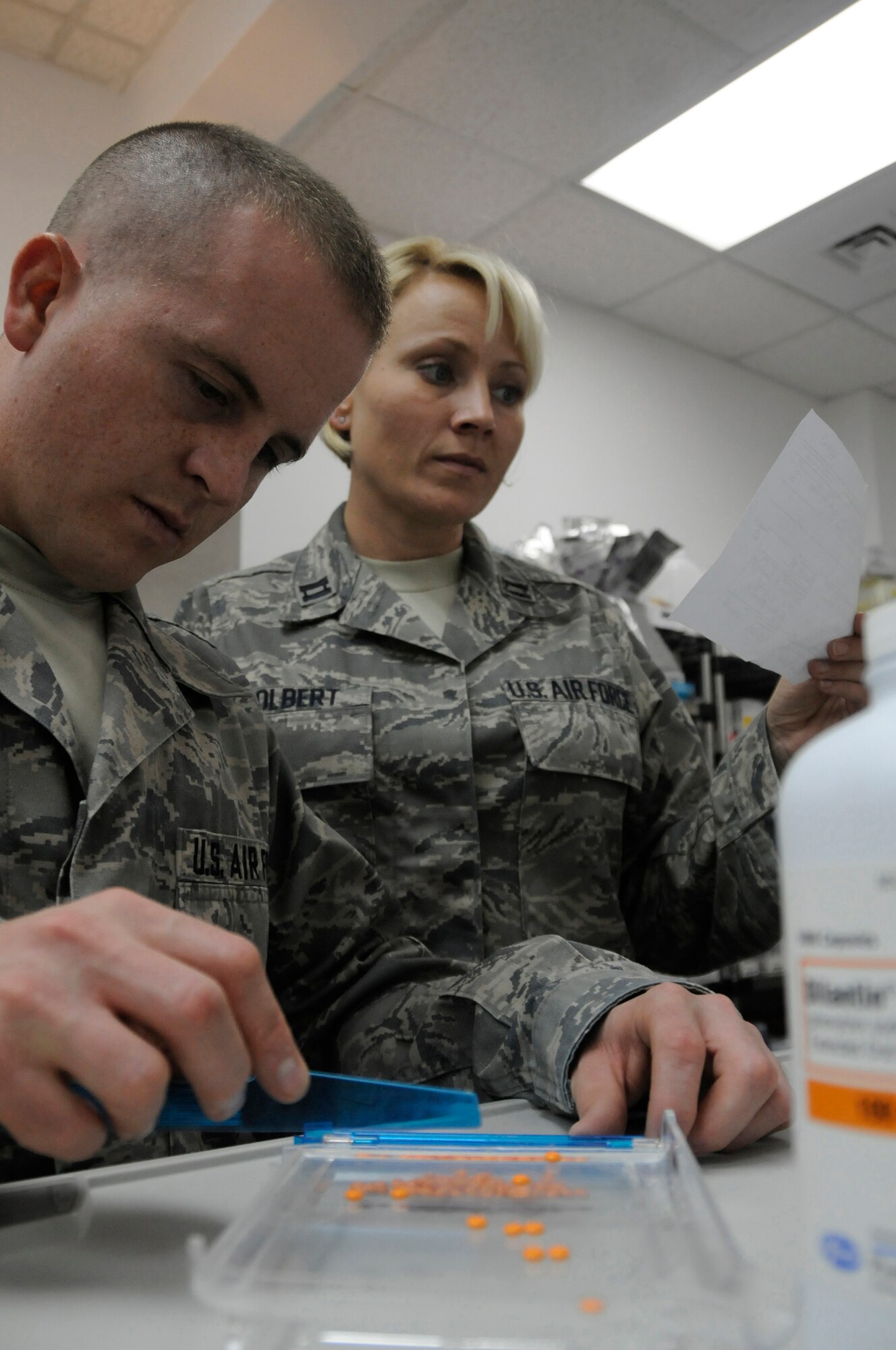 Staff Sgt. Allan Hogan, pharmacy technician assigned to the 379th Expeditionary Medical Group, counts the number of tablets he?s prescribing while Capt. Christine Tolbert, pharmacist assigned to the 379th EMDG, reads the patient?s prescription to ensure he receives the right type and quantity of medication Nov. 10, at an undisclosed air base in Southwest Asia.  The 379th EMDG maintain health and prevent spread of illness enabling deployed members to continue fighting the Global War on Terrorism. Sergeant Hogan, a native of Cambridge, Mass., is deployed from Maxwell Air Force Base, Ala.  Captain Tolbert hails from Oklahoma City, Okla., and is deployed from Tinker AFB, Okla. Both are deployed in support of Operations Iraqi and Enduring Freedom and Joint Task Force-Horn of Africa. (U.S. Air Force photo by Staff Sgt. Darnell T. Cannady/Released)