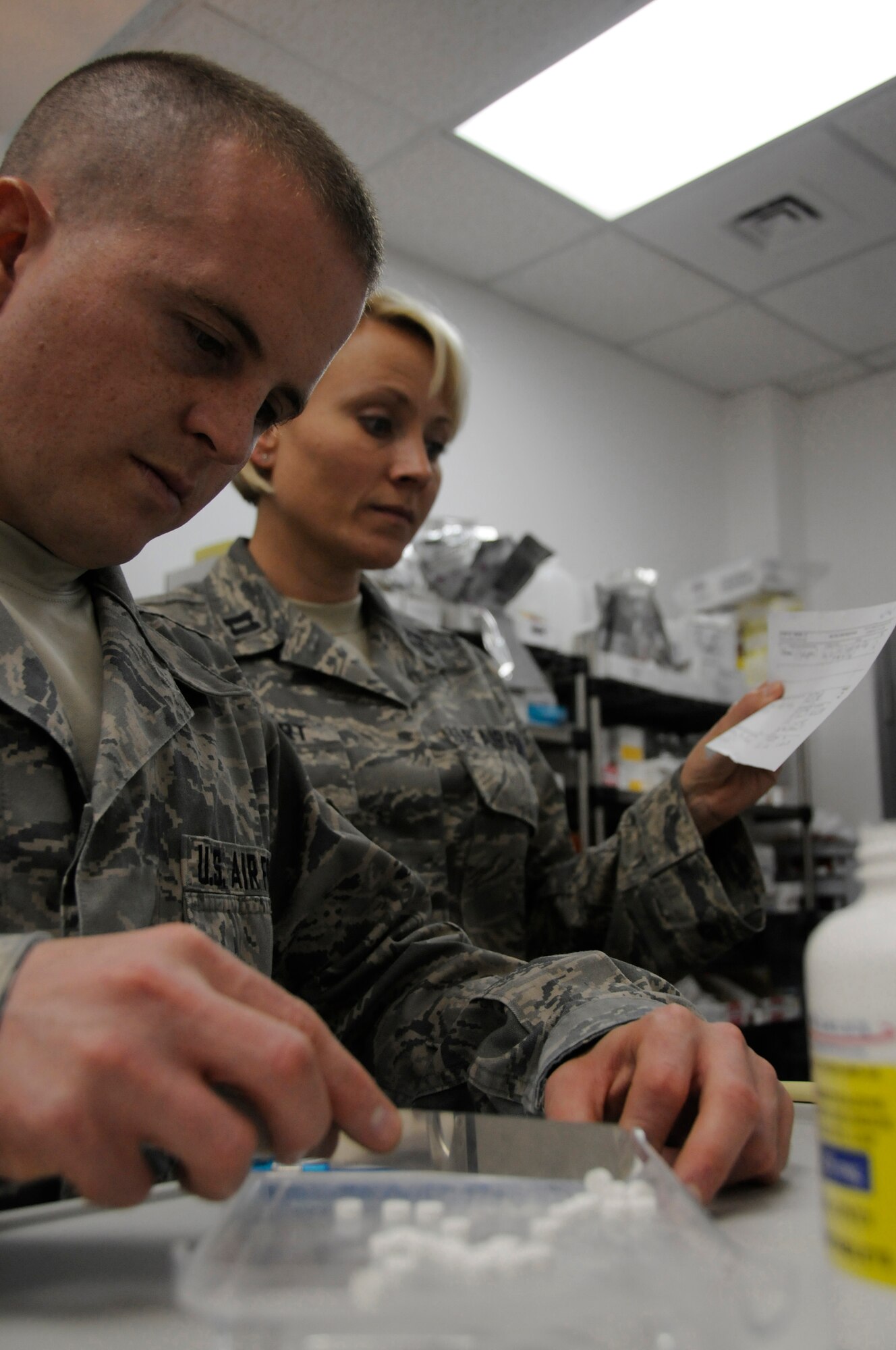 Staff Sgt. Allan Hogan, pharmacy technician assigned to the 379th Expeditionary Medical Group, counts the number of tablets he?s prescribing while Capt. Christine Tolbert, pharmacist assigned to the 379th EMDG, reads the patient?s prescription to ensure he receives the right type and quantity of medication Nov. 10, at an undisclosed air base in Southwest Asia.  The 379th EMDG maintain health and prevent spread of illness enabling deployed members to continue fighting the Global War on Terrorism. Sergeant Hogan, a native of Cambridge, Mass., is deployed from Maxwell Air Force Base, Ala.  Captain Tolbert hails from Oklahoma City, Okla., and is deployed from Tinker AFB, Okla. Both are deployed in support of Operations Iraqi and Enduring Freedom and Joint Task Force-Horn of Africa. (U.S. Air Force photo by Staff Sgt. Darnell T. Cannady/Released)