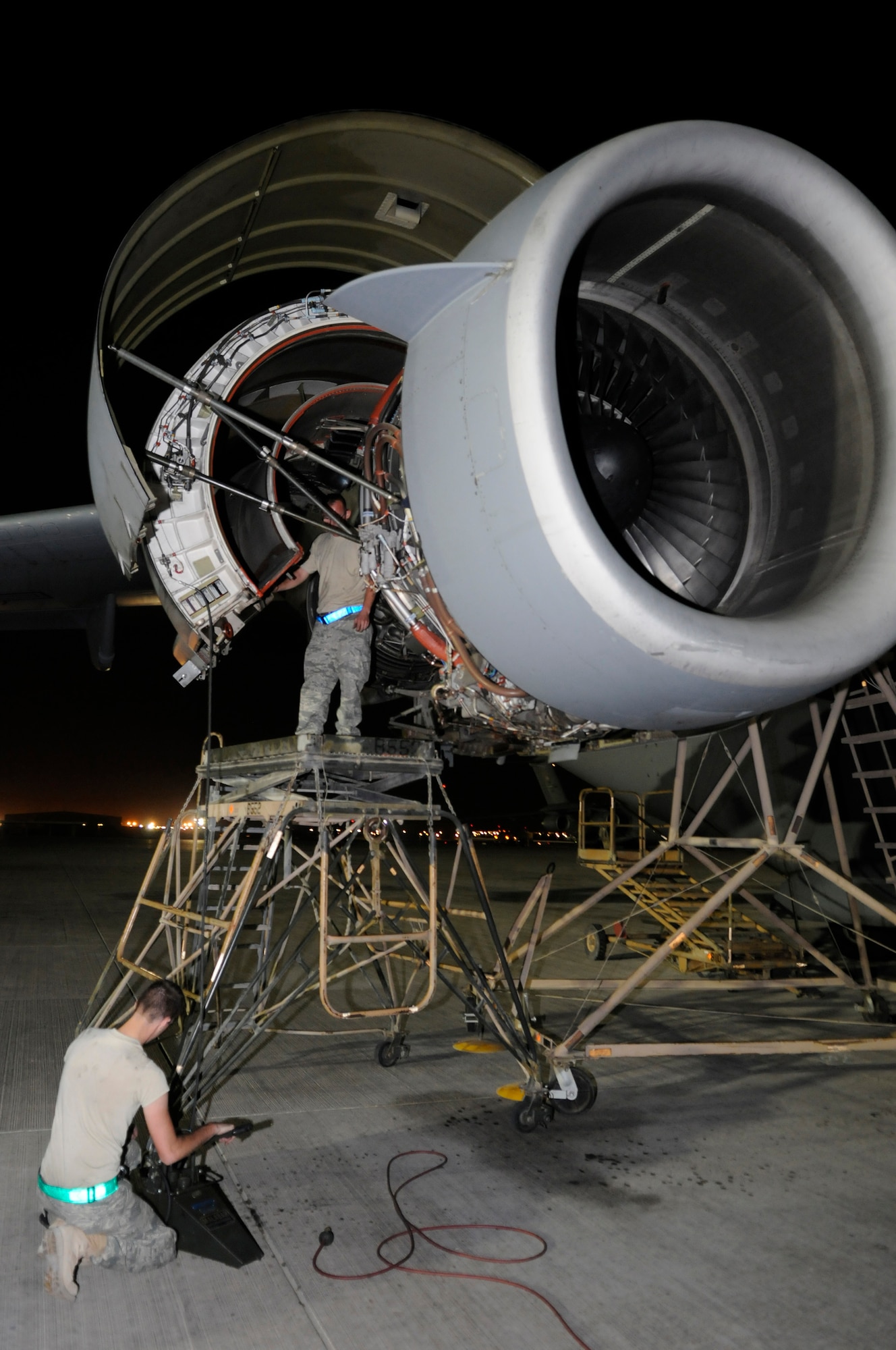 Airman 1st Class Eren Kipp pumps air into a valve holding up a cowling on a C-17 Globemaster III engine while Staff Sergeant Chad Laux disconnects the cowl door rod prior to trouble shooting the shut-off valve, Nov. 10, at an undisclosed air base in Southwest Asia.  The team works its way down a checklist until the shut-off valve problem is solved.  The C-17 is capable of rapid strategic delivery of troops and all types of cargo to main operating bases or directly to forward bases in the Central Command area of responsibility.  Sergeant Laux and Airman Kipp are both aircraft electrical & environmental systems technicians assigned to the 8th Expeditionary Air Mobility Squadron, deployed from Charleston Air Force Base, S.C., in support of Operations Iraqi and Enduring Freedom and Joint Task Force Base-Horn of Africa.  (U.S. Air Force photo by Tech. Sgt. Michael Boquette/Released)  