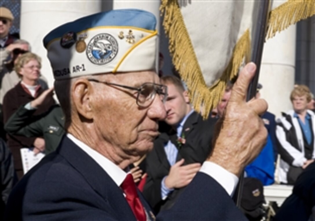 A World War II veteran carries a ceremonial flag during a Veterans Day ceremony at the Tomb of the Unknown Soldier at Arlington National Cemetery, Nov. 11, 2008.  