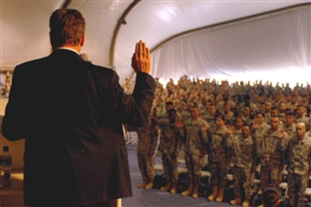 Robert Looney,  director of the Bangkok District Office of  U.S. Citizenship and Immigration Services, administers the oath of naturalization to 77 servicemembers on Bagram Air Field, Afghanistan, Nov. 11, 2008.