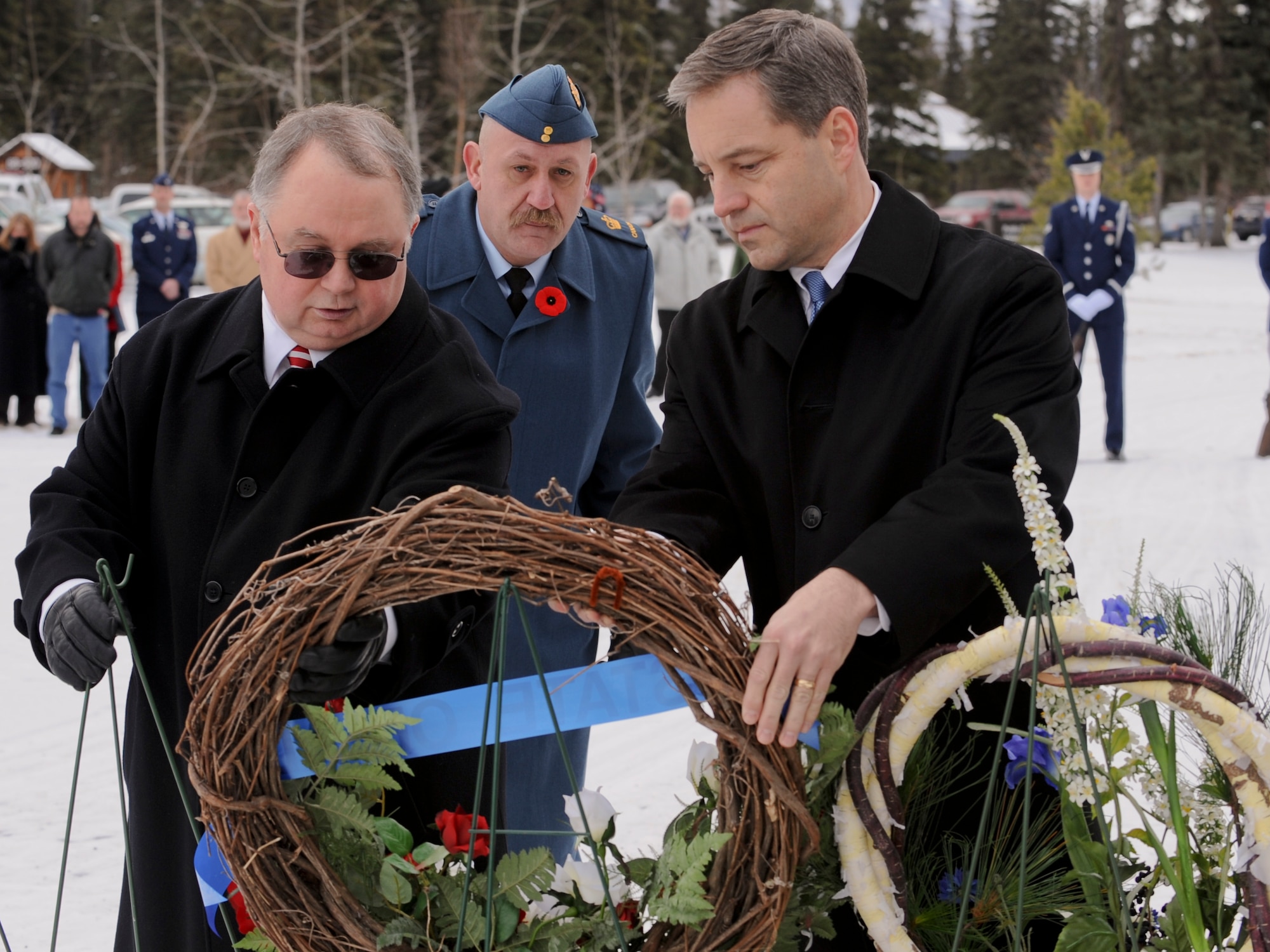 FORT RICHARDSON, Alaska -- Jay Pullins (left) and Lt. Governor Sean Parnell (right) hang a wreath during the Veterans Day ceremony at Fort Richardson National Cemetery Nov. 11. The ceremony commemorated all those who paid the ultimate sacrifice for their country. Air Force alongside Army and Canadian forces were present for the ceremony. (U.S. Air Force photo/Staff Sgt. Joshua Garcia)