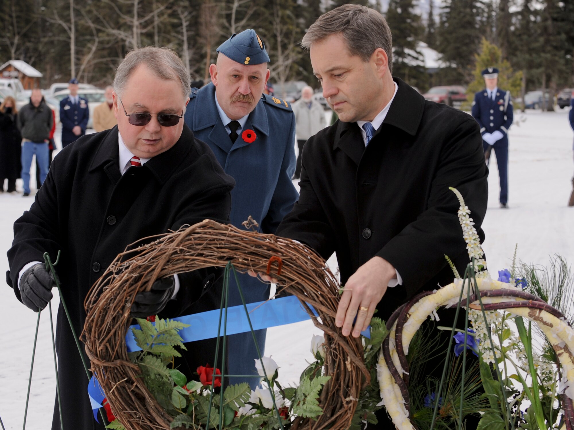 FORT RICHARDSON, Alaska -- Jay Pullins (left) and Lt. Governor Sean Parnell (right) hang a wreath during the Veterans Day ceremony at Fort Richardson National Cemetery Nov. 11. The ceremony commemorated all those who paid the ultimate sacrifice for their country. Air Force alongside Army and Canadian forces were present for the ceremony. (U.S. Air Force photo/Staff Sgt. Joshua Garcia)