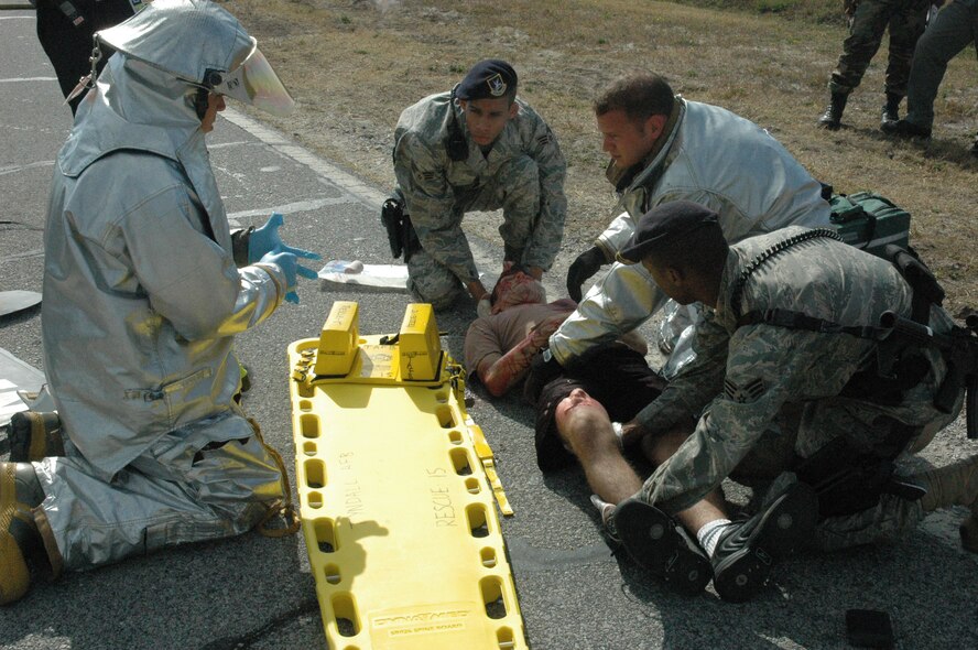 325th Security Forces Squadron personnel and 325th Civil Engineer Squadron fire fighters team up to aid a car-accident victim during an exercise Wednesday at Tyndall Air Force Base.  Wednesday's exercise focused on a severe weather warning.  (U.S. Air Force photo by Airman 1st Class Anthony J. Hyatt)