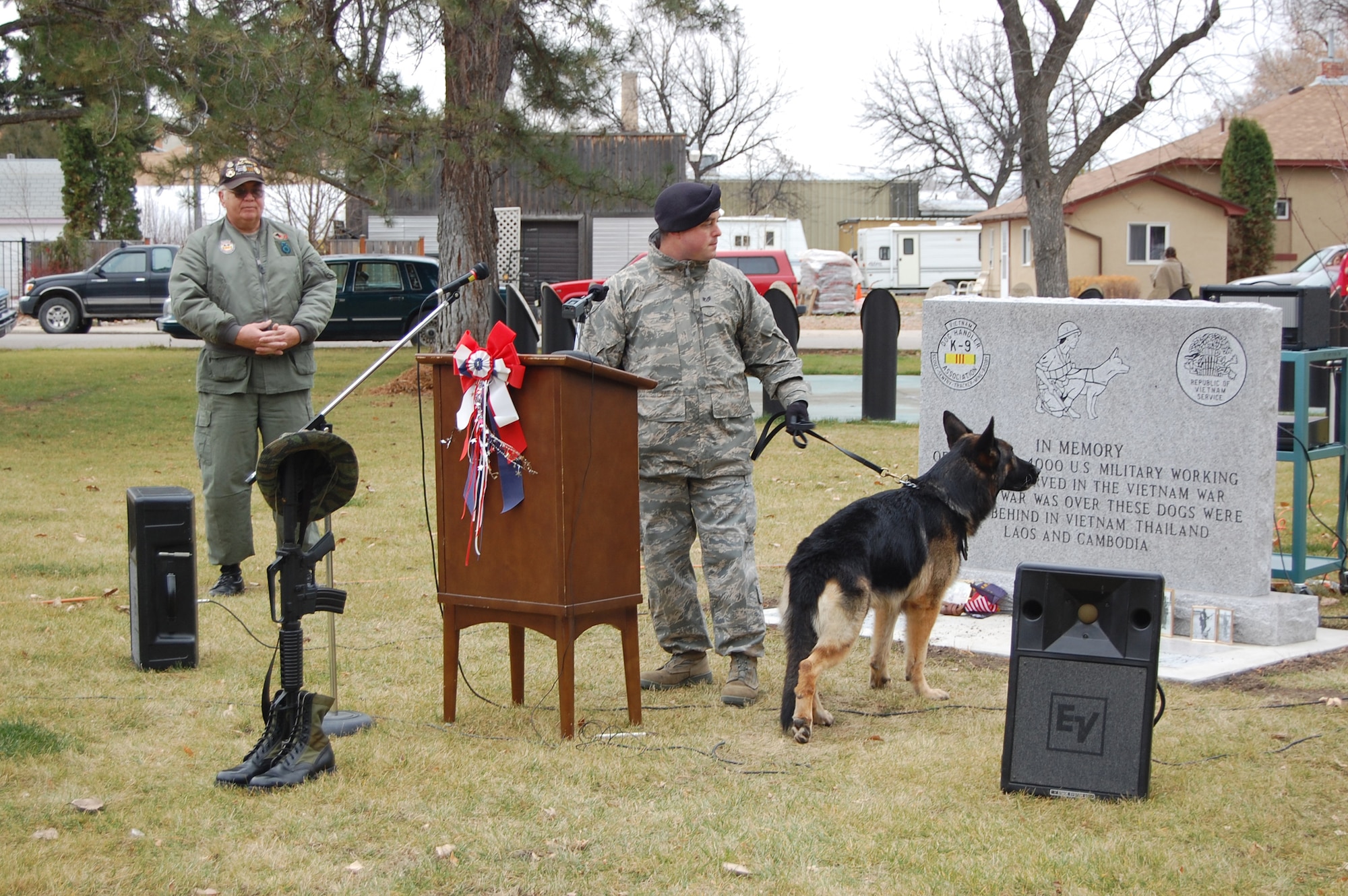 Staff Sgt. Mark Chandler, 341st Security Forces Group K-9 handler, stands with his dog, Kajo, during a Military Working Dog memorial dedication ceremony at Fort Benton Nov 11. Sergeant Chandler explained to the crowd what commands are used with the dogs. (U.S. Air Force photo/Senior Airman Emerald Ralston)
