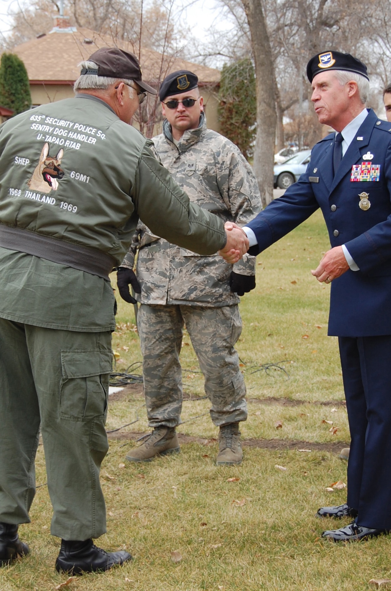 Ron Saville, a veteran in Fort Benton who helped organize the ceremony and memorial, shakes hands with Col. John. Probst, 341st Security Forces Group commander, while members of Malmstrom's K-9 unit look on. A Veterans day ceremony and Military Working Dog memorial ceremony were held in Fort Benton Nov. 11. (U.S. Air Force photo/Senior Airman Emerald Ralston)