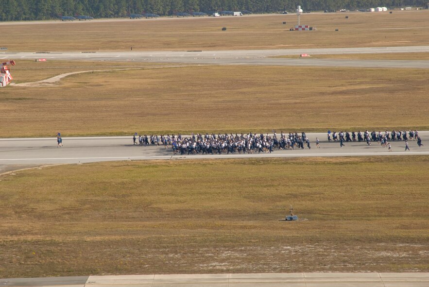 The 325th Fighter Wing personnel conduct a fun-run down the flightline grouped by squadrons Monday during Sports Day.  (U.S. Air Force photo by Susan Trahan) 