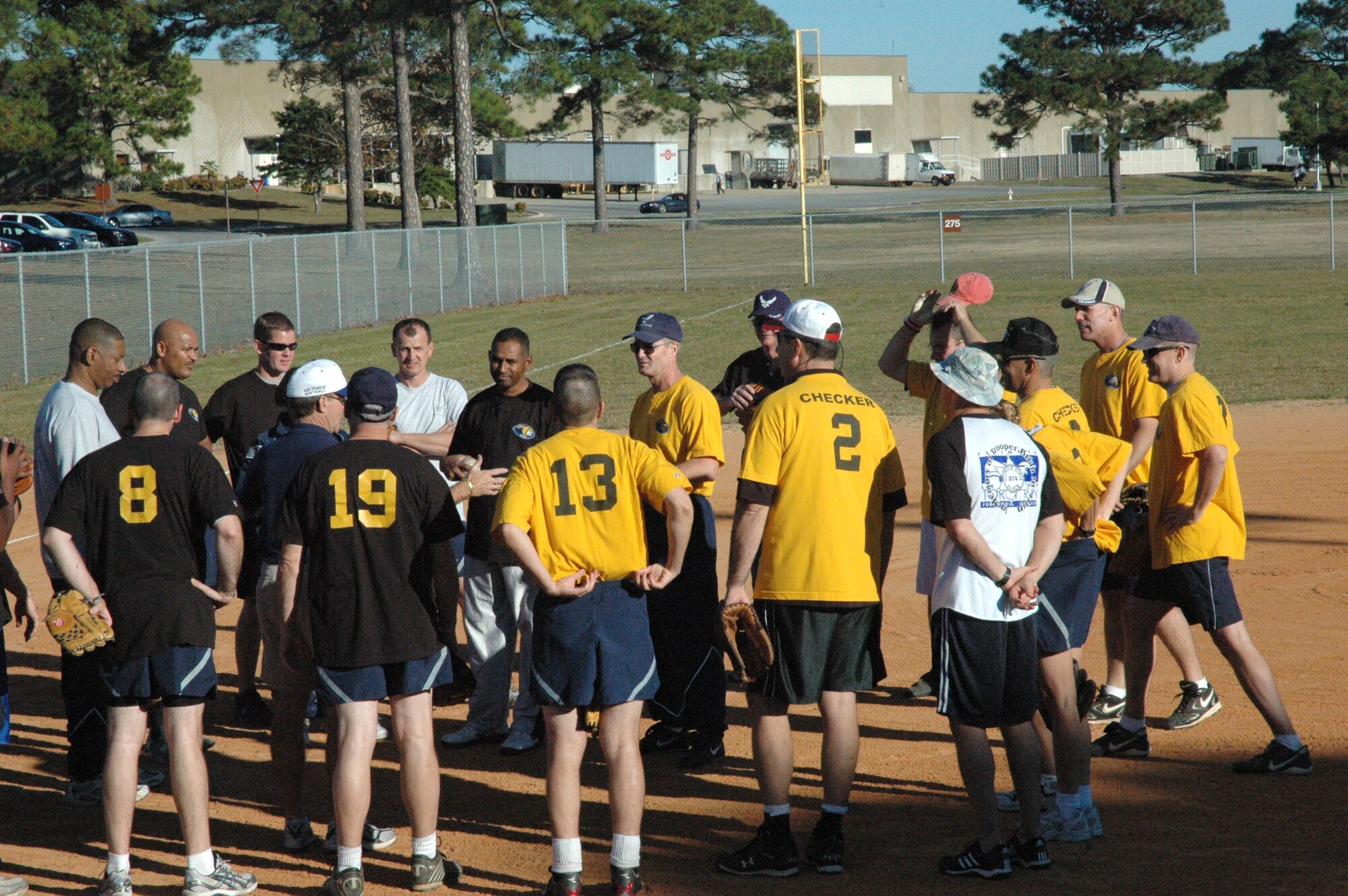 Before the Chiefs vs. Eagles softball game, all team members gather together to hear the rules of engagement. (U.S. Air Force photo by Staff Sgt. Vesta M. Anderson)