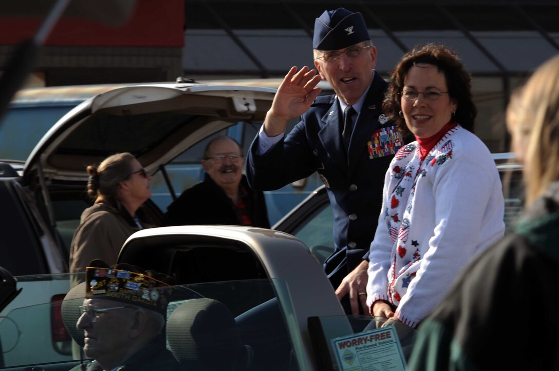 Col. Scott Vander Hamm, 28th Bomb Wing commander, and wife, Joanna, wave at spectators during a parade in downtown Rapid City, S.D., Nov. 11. Rapid City hosted this parade, which took place on Main Street, in honor of Veterans Day. (U.S. Air Force photo/Airman Corey Hook)