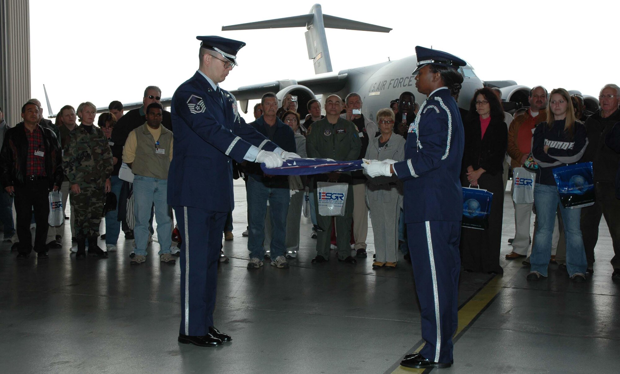 MCGUIRE AIR FORCE BASE, NJ -- Employers watch as Reserve honor guards perform a flag folding ceremony during the 514th Air Mobility Wing's annual Employer Appreciation Day here. The employers also participated in a simulated deployment process that included a flight on a KC-10 Extender or C-17 Globemaster III. (U.S. Air Force photo/SrA. William P. O'Neil III)