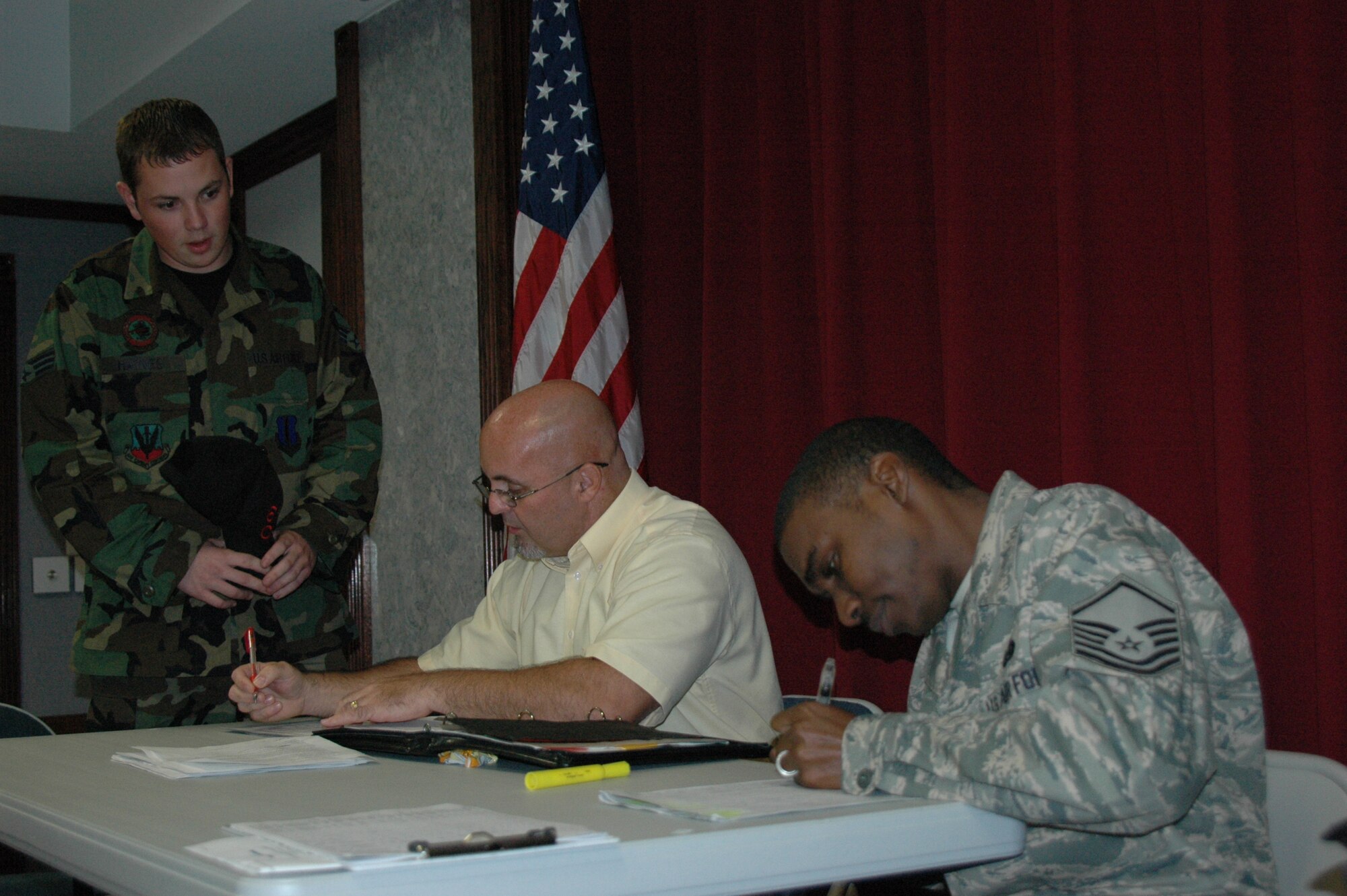 Senior Airman Scott Haynes, 60th Aircraft Maintenance unit electronics and environmental systems journeyman, waits in anticipation to find out if there is an opening for him at McConnell AFB, Kansas. Dwight Bell, right, who is temporarily at the 33rd Fighter Wing facilitating the first group of drawdown assignments gave the Airman the good news that he'll be near family and have an opportunity to maintain KC-135 aircraft. Mr. Bell is Air Combat Command's superintendant of force structuring and works closely with Master Sgt. Hareech Carswell of the wing, far right, in aiding the assignment process of a phased wing drawdown. The first group of 250 will soon have their next duty preference in the system at the Air Force Personnel Center after a week of assignment processing held here Nov. 10-13. Orders will have a June report date but, if officially agreed upon, members can leave sooner.  The next group of 600 will go through the same process in February and ship out in the summer, while the last group will begin their assignment notification. Personnel moves are part of the 33rd FW's ongoing transition into becoming the international training center for F-35 Lightning II. (U.S. Air Force Photo/Chrissy Cuttita)