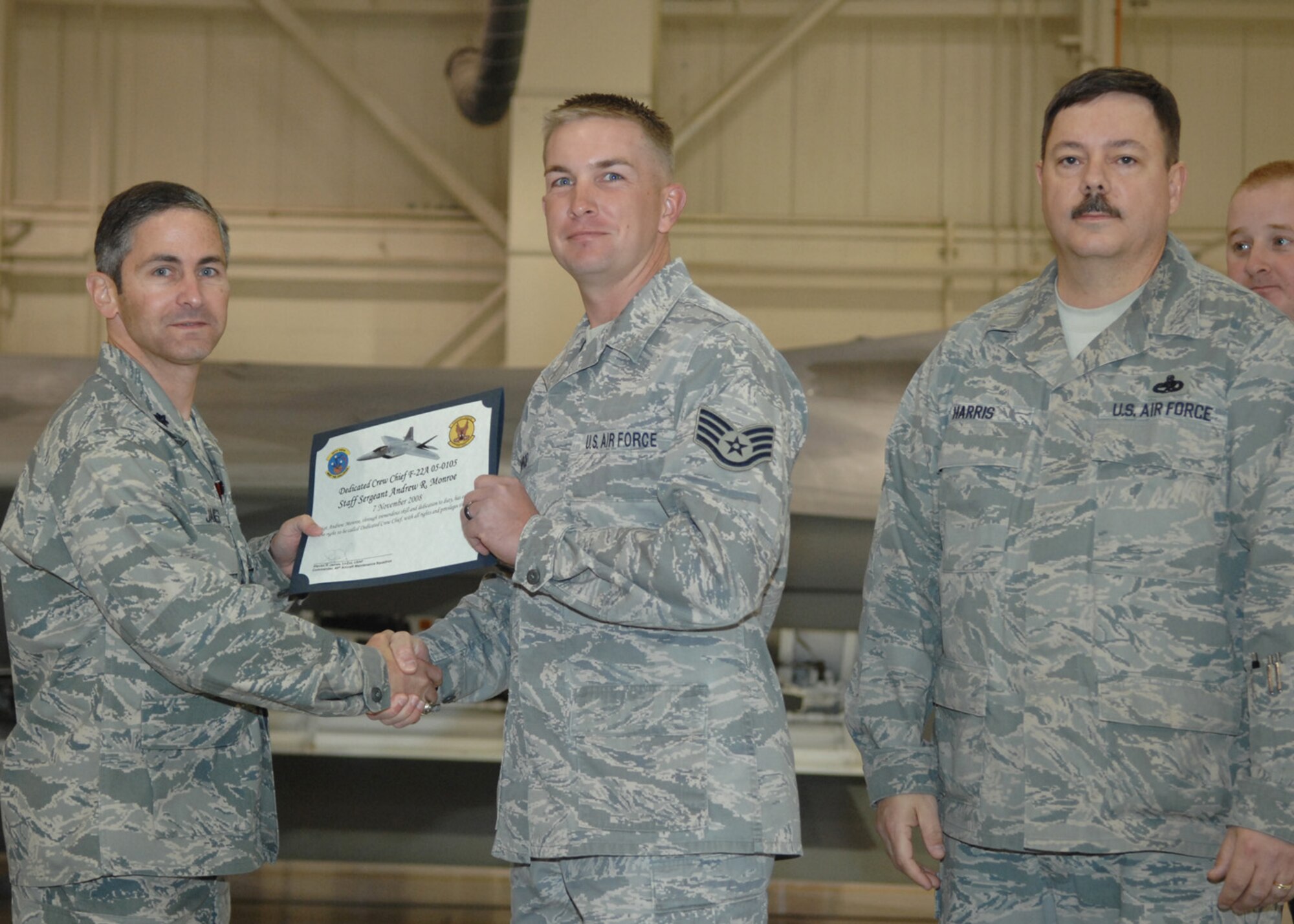 Staff Sgt. Andrew Monroe, 49th Aircraft Maintenance Squadron, receives the Dedicated Crew Chief award by Lt. Col. Steve James, 49th Aircraft Maintenance Squadron commander, at Holloman Air Force Base, N.M., Nov. 7. Airmen were recognized at the ceremony for their exceptional job performance. (U.S. Air Force photo/Airman 1st Class Veronica Salgado)