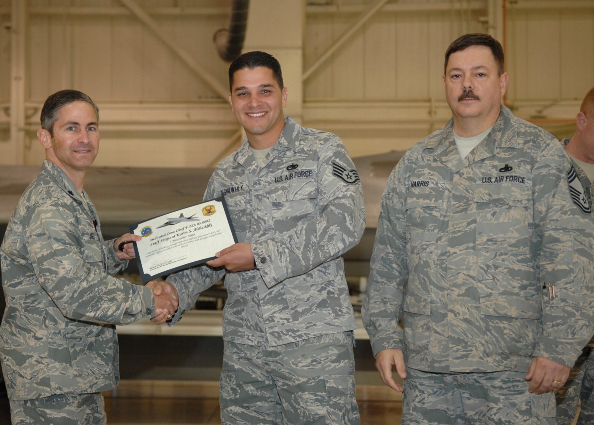 Staff Sgt. Karim Alshakhly, 49th Aircraft Maintenance Squadron, receives the Dedicated Crew Chief award by Lt. Col. Steve James, 49th Aircraft Maintenance Squadron commander, at Holloman Air Force Base, N.M., Nov. 7. Airmen were recognized at the ceremony for their exceptional job performance. (U.S. Air Force photo/Airman 1st Class Veronica Salgado)