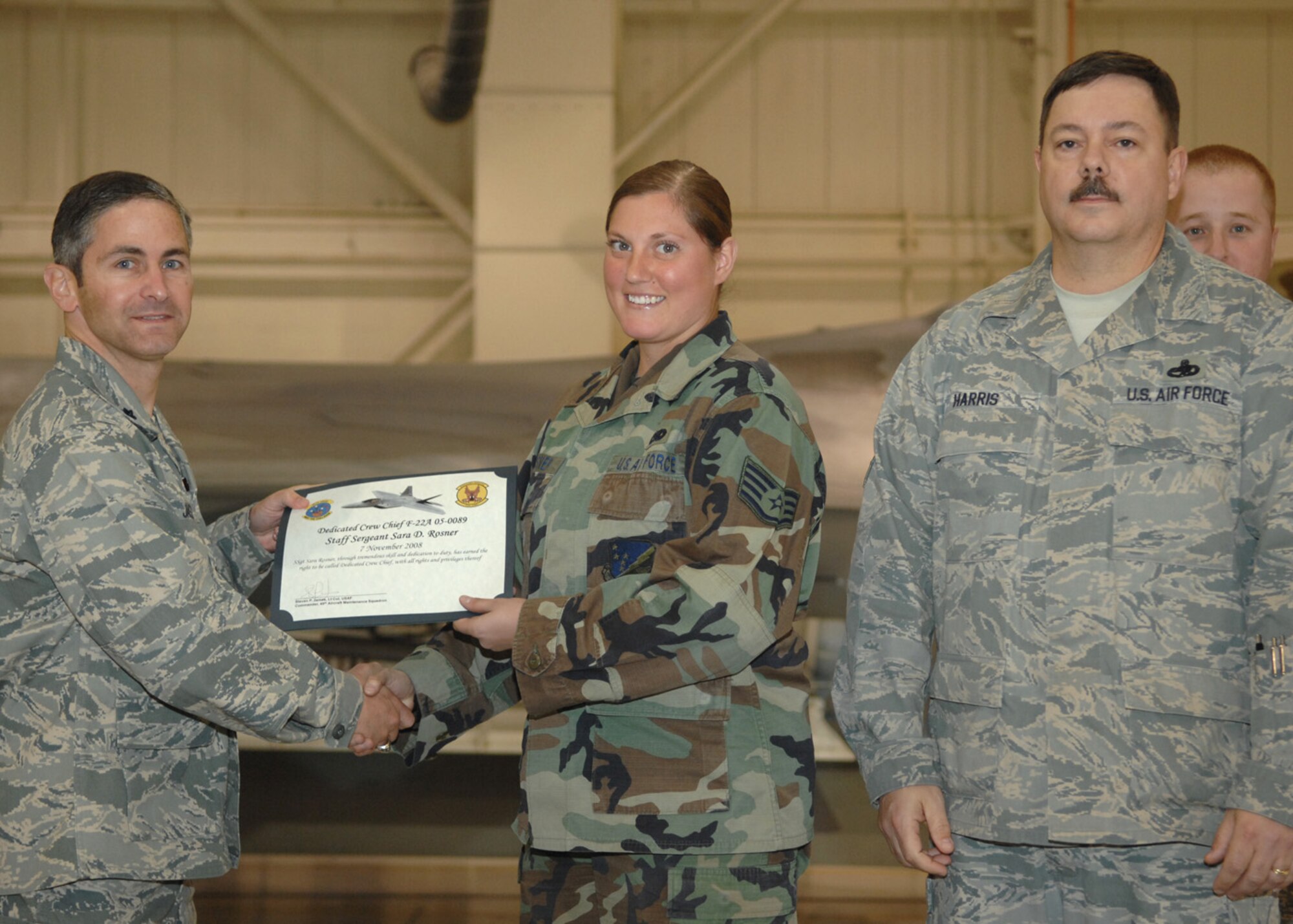 Staff Sgt. Sara Rosner, 49th Aircraft Maintenance Squadron, receives the Dedicated Crew Chief award by Lt. Col. Steve James, 49th Aircraft Maintenance Squadron commander, at Holloman Air Force Base, N.M., Nov. 7. Airmen were recognized at the ceremony for their exceptional job performance. (U.S. Air Force photo/Airman 1st Class Veronica Salgado)