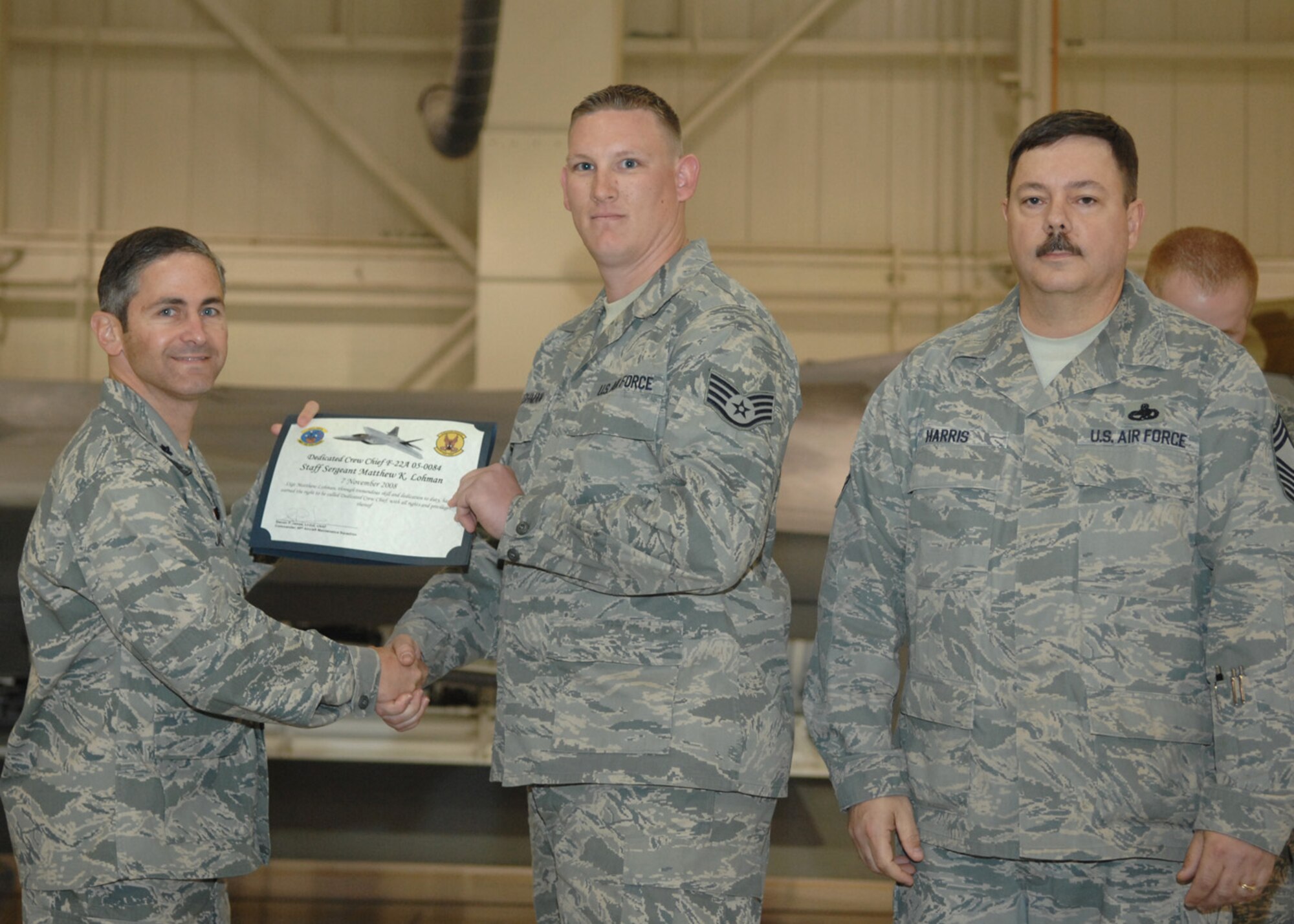 Staff Sgt Matthew Lohman, 49th Aircraft Maintenance Squadron, receives the Dedicated Crew Chief award by Lt. Col. Steve James, 49th Aircraft Maintenance Squadron commander, at Holloman Air Force Base, N.M., Nov. 7. Airmen were recognized at the ceremony for their exceptional job performance. (U.S. Air Force photo/Airman 1st Class Veronica Salgado)