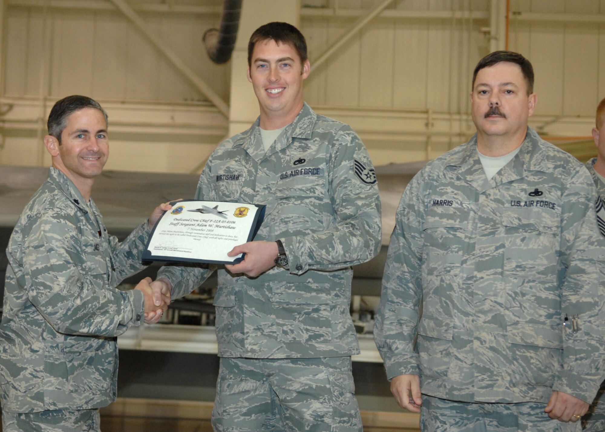 Staff Sgt. Adam Murtishaw, 49th Aircraft Maintenance Squadron, receives the Dedicated Crew Chief award by Lt. Col. Steve James, 49th Aircraft Maintenance Squadron commander, at Holloman Air Force Base, N.M., Nov. 7. Airmen were recognized at the ceremony for their exceptional job performance. (U.S. Air Force photo/Airman 1st Class Veronica Salgado)