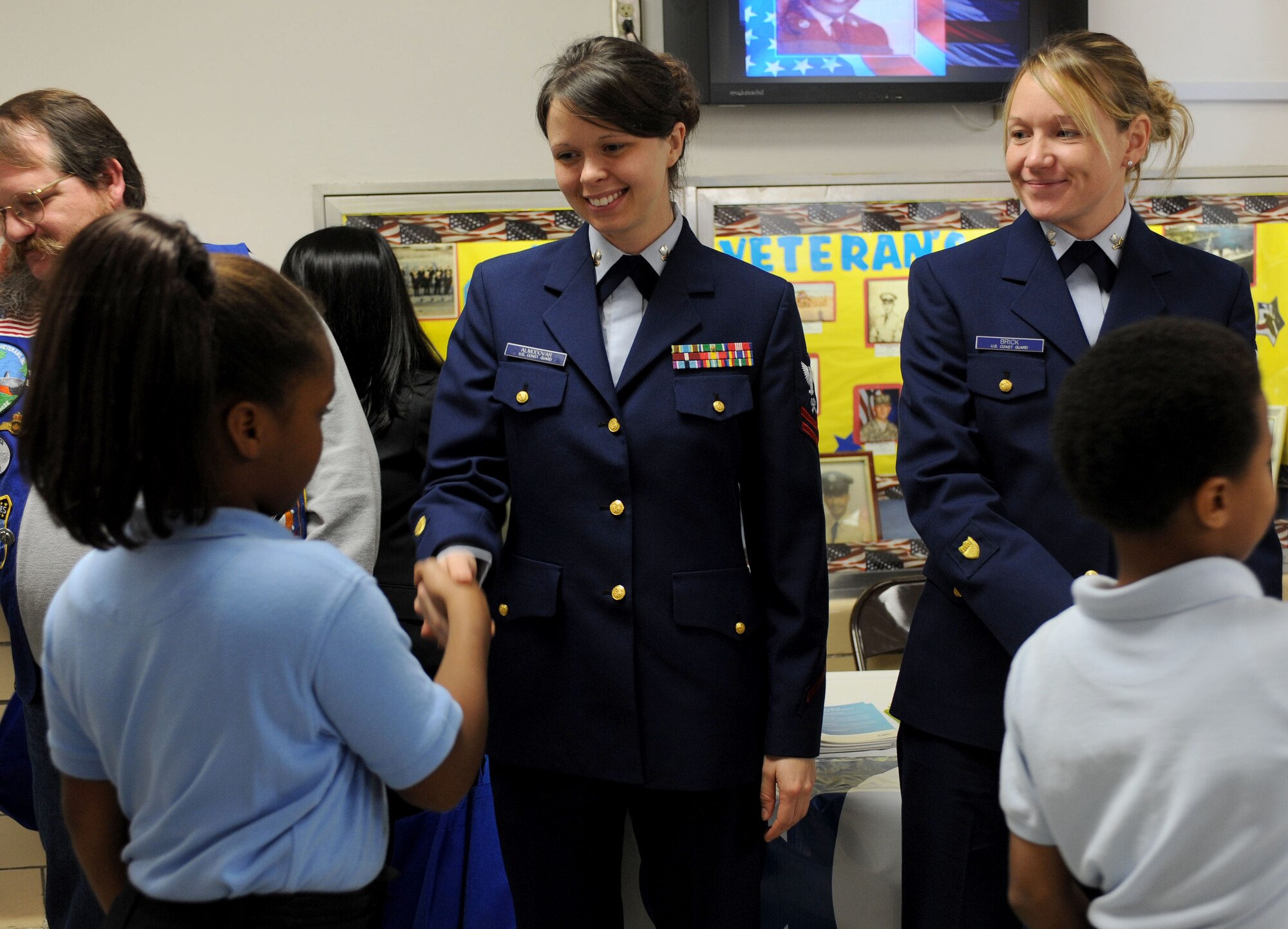 LANGLEY AIR FORCE BASE, Va.-- Petty Officers 2nd Class Chandra Almodovar and Heather Brick, from the Coast Guard Training Center at Yorktown, greet children during the "Take a Veteran to School Day" at Jane H. Bryan Elementary School Nov. 11. This event gave Hampton school children a chance to meet and honor local servicemembers and veterans. (U.S. Air Force photo/Airman Rebecca Montez)