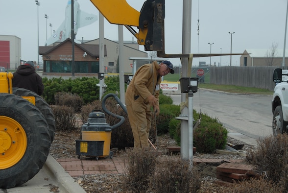 Kieth Anderson of T.F. Powers Construction works at removing flag poles at the current main entrance to the North Dakota Air National Guard.  The flag poles will be moved and placed at the new entrance located north of the base on 32nd Avenue north.
