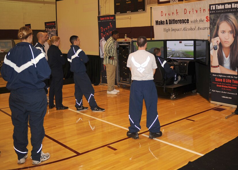 Members of the 4th Fighter Wing watch as an Airman uses the drunk driving simulator here at the Save-a-Life tour  Nov. 10, 2008 at Seymour Johnson Air Force Base, N.C. The tour is being held to promote drunken driving awareness and prevention.(US Air Force photo by Airman First Class Ciara Wymbs)