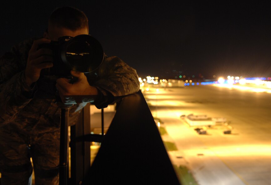 WHITEMAN AIR FORCE BASE, Mo – Airmen 1st Class Carlin Leslie, 509th Bomb Wing Public Affairs, captures images of the flight line from the air traffic control tower’s catwalk Nov. 6. The 509th Bomb Wing Public Affairs is the focal point for providing information on Whiteman issues, programs and base events to Airmen, the community and members of the news media. The staff conducts base tours, provides speakers for civic organizations in the community, and is the commander's liaison between the base and media organizations. All media requests concerning Whiteman people, programs and events must be coordinated through Public Affairs.  (U.S. Air Force photo/Senior Airman Stephen Linch)