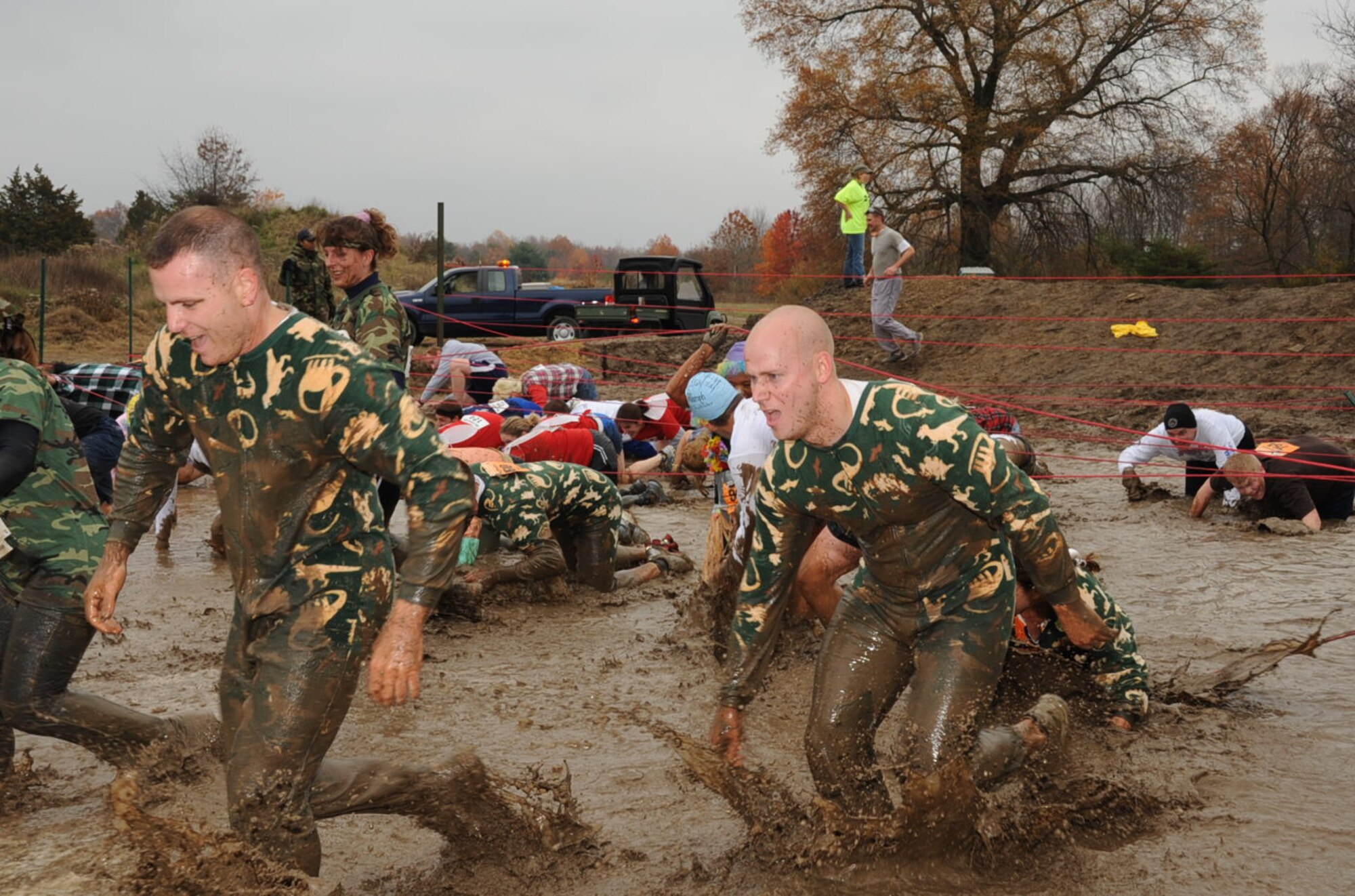 Runners (like the ones dressed in pajamas) were drenched in mud as they hit the first obstacle of the McGuire Mud Run Nov. 8. Many team participants were dressed in costumes for the duration of the 10K run. The Burlington County Military Affairs Committee, which sponsored the marathon, hopes to make it an annual event. (U.S. Air Force photo/Capt. Darrick Lee)