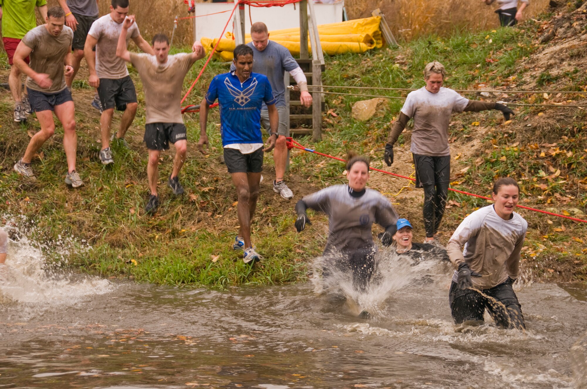 Col. Balan Ayyar, 305th Air Mobility Wing commander, charges into the water as he crosses a creek during the McGuire Mud Run Nov. 8. The 10K run, sponsored by the Burlington County Military Affairs Committee, took runners through a variety of challenging, muddy obstacles. (U.S. Air Force photo/Staff Sgt. Robert Edwards)