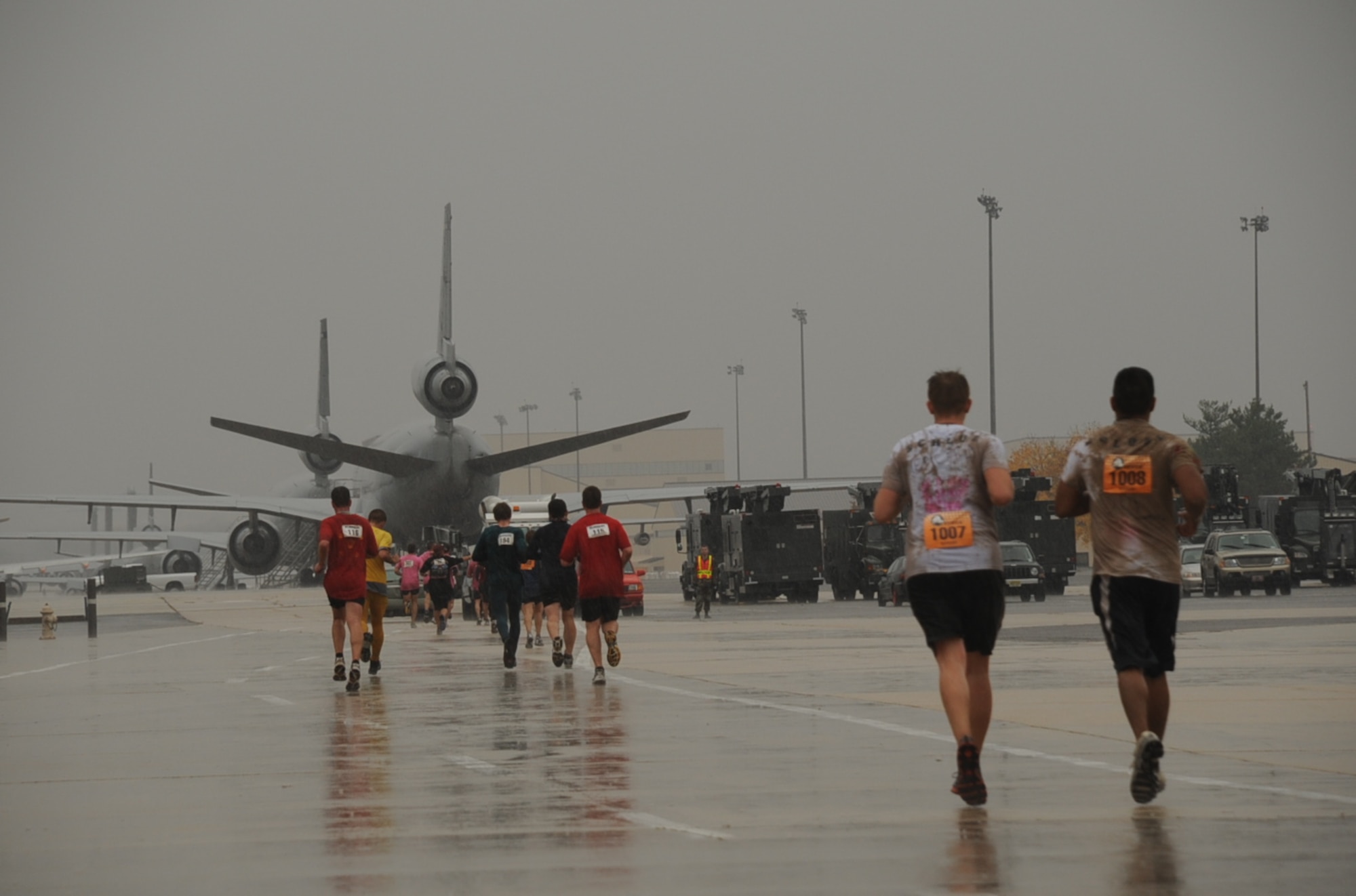 Runners get a tail-end view of air power Nov. 8 during the first McGuire Mud Run. The run, sponsored by the Burlington County Military Affairs Committee, challenged participants with a low-crawl through a mud pit and other obstacles during the 10K marathon. (U.S. Air Force photo/Capt. Darrick Lee)