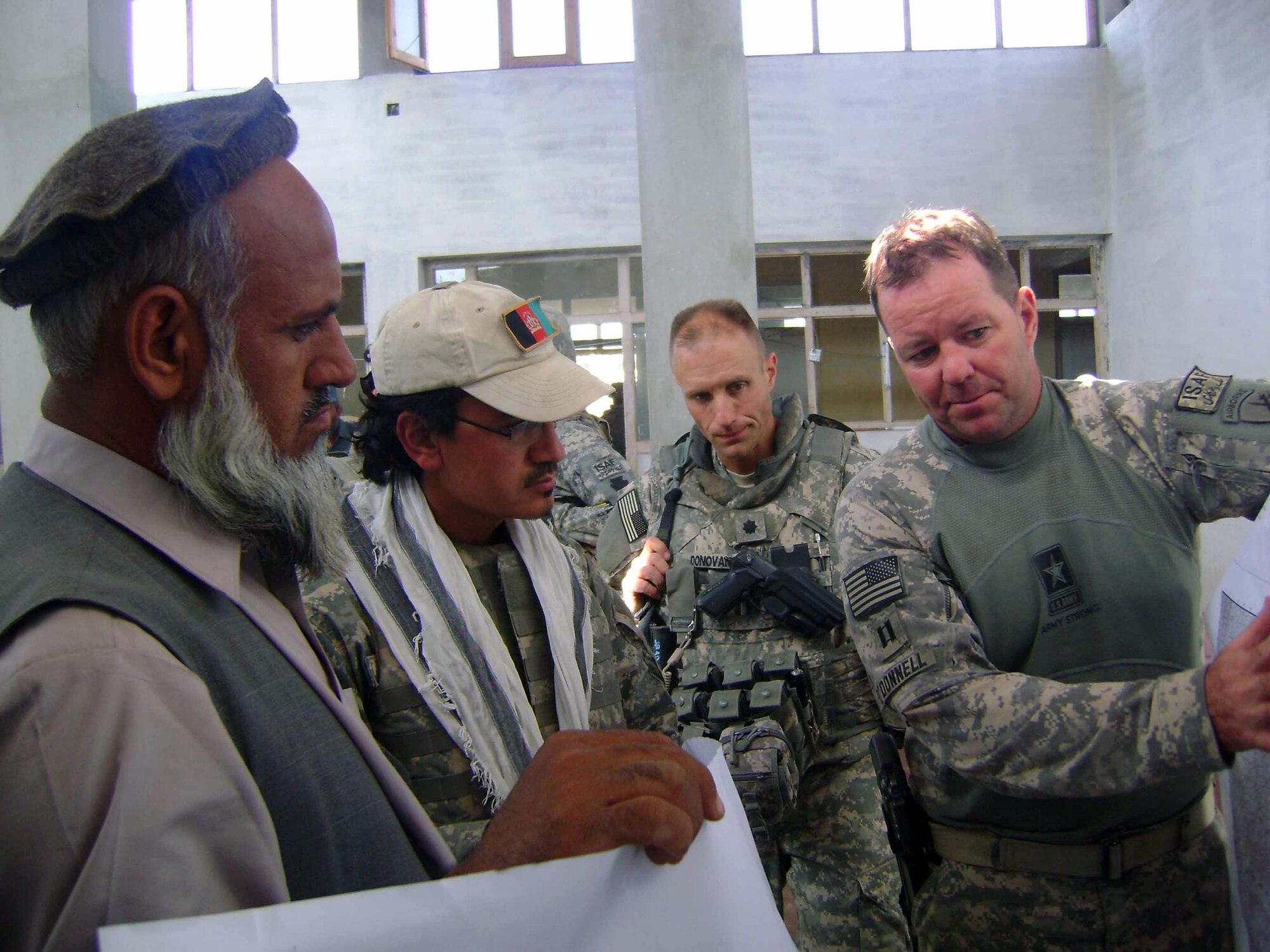 Army Capt. Timothy O'Donnell and Lt. Col. Paul Donovan discuss the placement of development projects in the Hisarek District Nov. 8 in the Nangarhar Province of Afghanistan. Both are part of the Nangarhar Provincial Reconstruction Team. The PRT is made up of Airmen and Soldiers from around the world and is charged with assisting the provincial government in improving security, governance and reconstruction. Colonel Donovan is the Nangarhar PRT commander. (Courtesy photo) 
