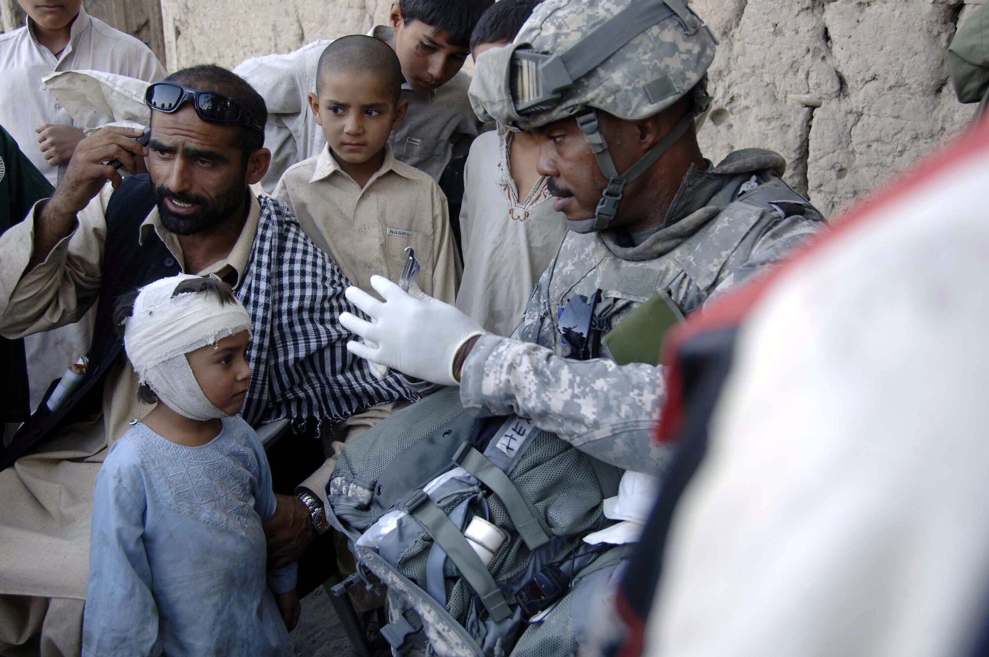 Tech. Sgt. William Allison provides medical aid to an Afghan child during a foot patrol Nov. 8 in the Nangarhar Province of Afghanistan. He is part of the Nangarhar Provincial Reconstruction Team that is made up of Airmen and Soldiers charged with assisting the provincial government in improving security, governance and reconstruction. Sergeant Allison is a native of Detroit and assigned to Dover Air Force Base, Del. (Courtesy photo) 
