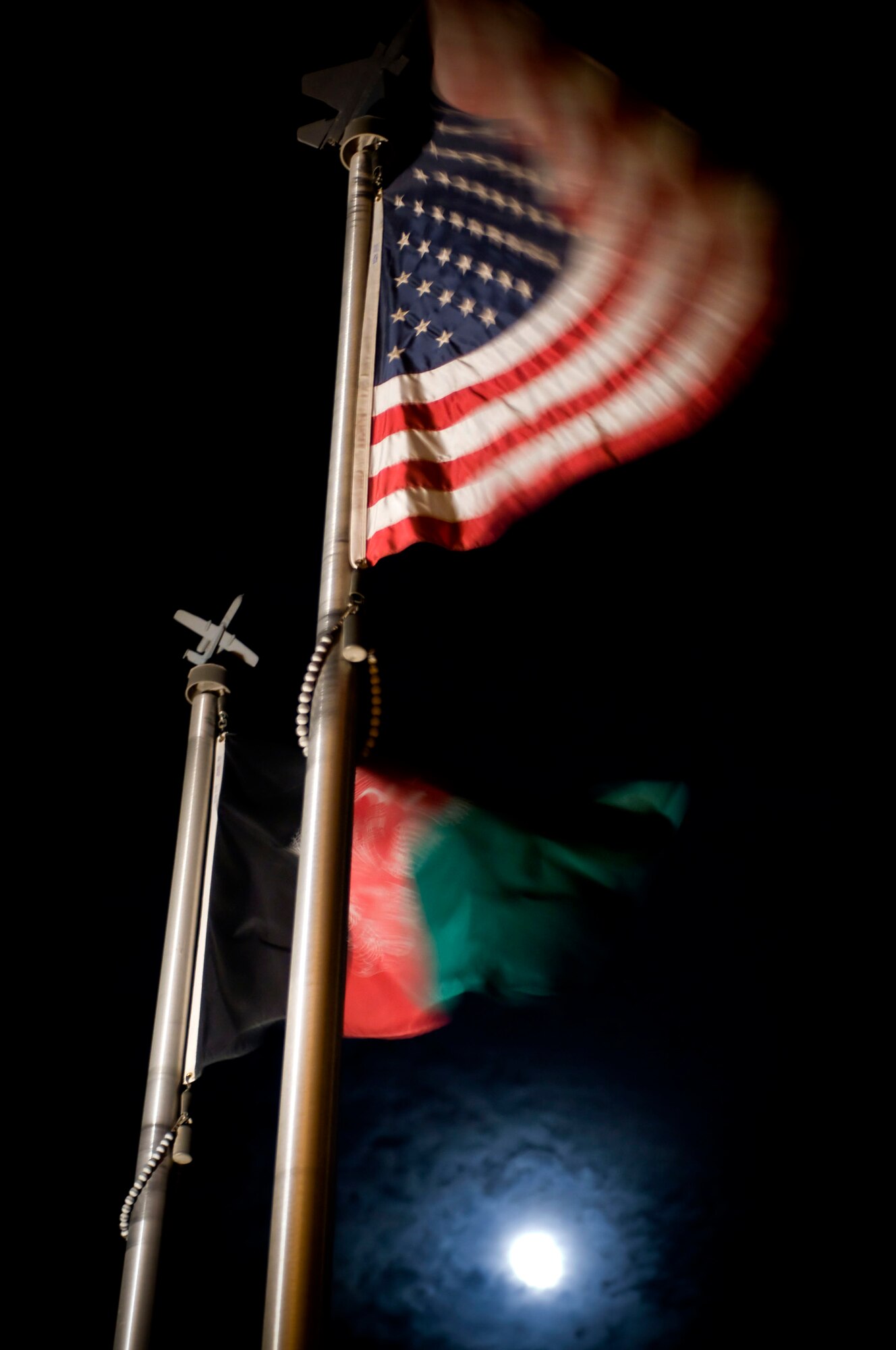 An American and Afghan flag wave proudly together at Bagram Air Field, Afghanistan, Nov. 11. The American flag was raised back to full-mast at the end of Veterans Day, rejoining its Afghan counterpart, a symbol of the ongoing cooperation between the U.S. and Afghanistan. (U.S. Air Force photo by Staff Sgt. Samuel Morse/Released)
