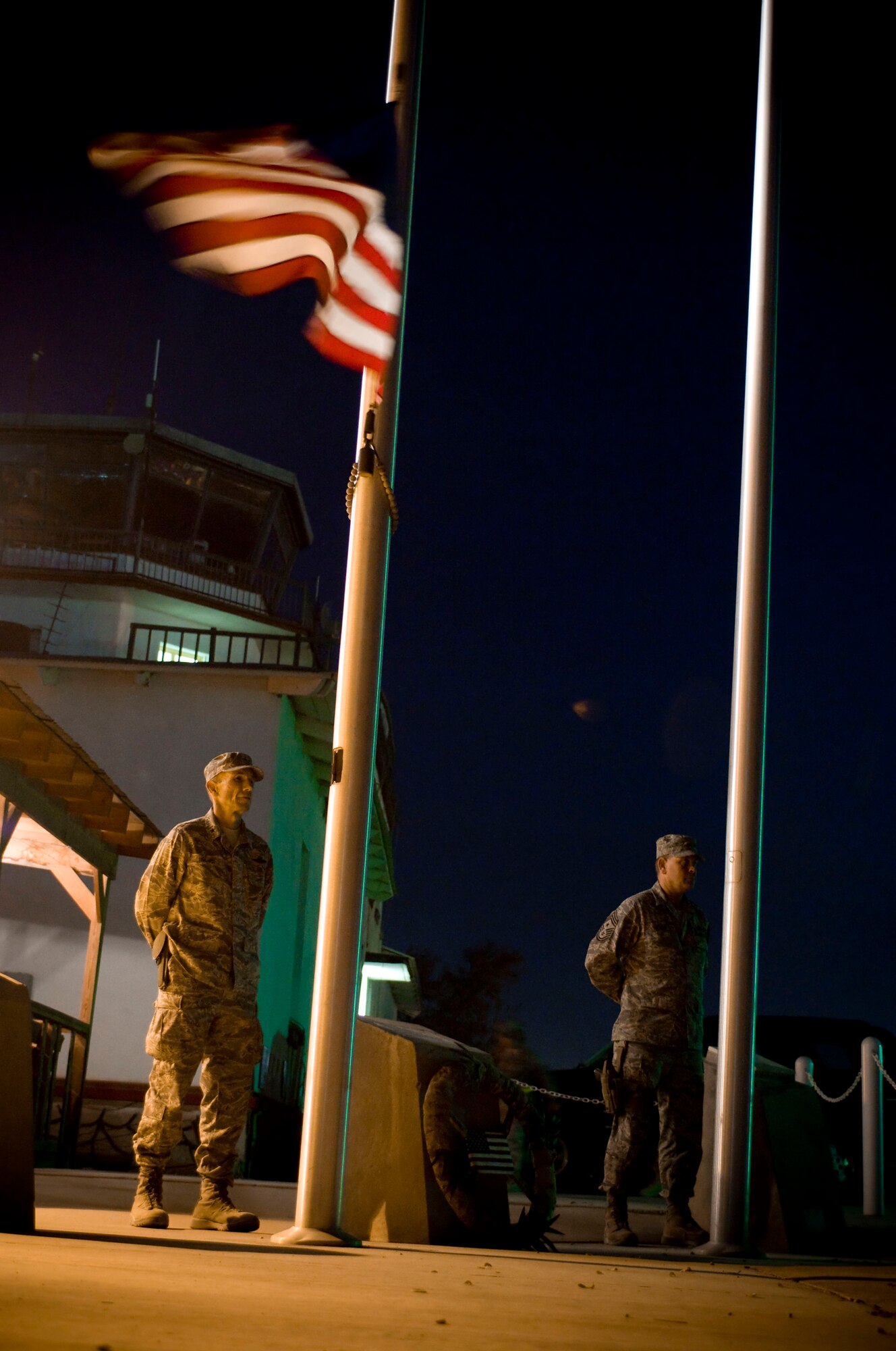 Brig. Gen. Mike Holmes, 455th Air Expeditionary Wing commander, and Command Chief Master Sgt. Ray Clark hold silent vigil by the Camp Cunningham flagpoles at Bagram Air Field, Afghanistan, Nov. 11. General Holmes and Chief Clark lead the vigil, taking both the first and last watches of the day. (U.S. Air Force photo by Staff Sgt. Samuel Morse/Released)