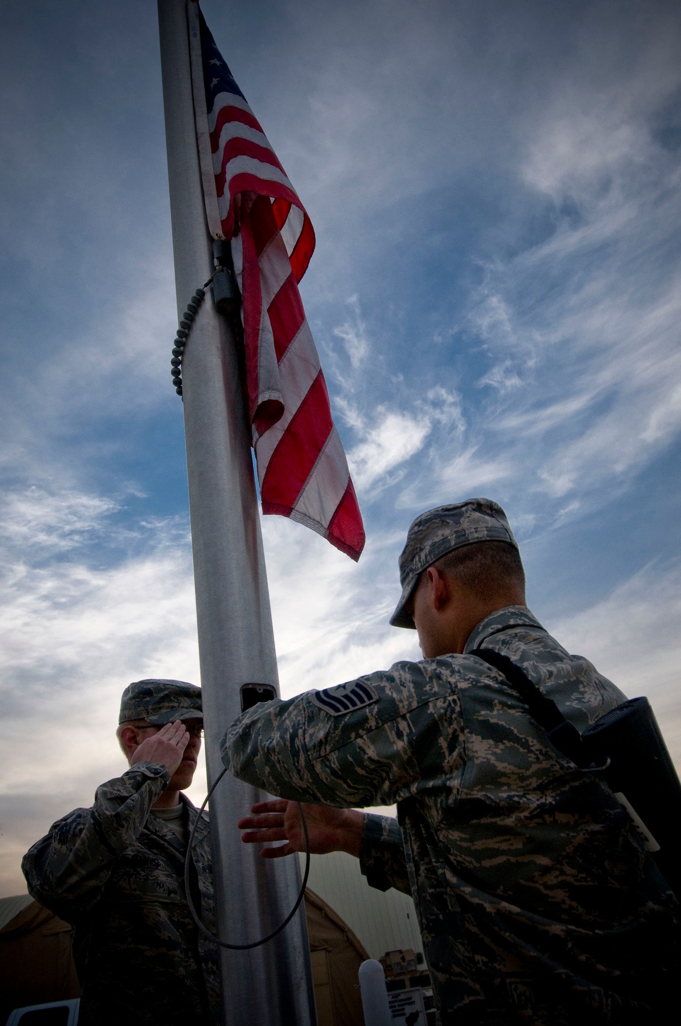 Senior Airman Joshua Hawks, 455th Expeditionary Communications Squadron, Tech. Sgt. Rolando Barrera, 455th Expeditionary Civil Engineer Squadron, and Master Sgt. Amado Azua, 455th Expeditionary Mission Support Group, lower the American flag to half-mast at Bagram Air Field, Afghanistan, Nov. 11. The Airmen of the 455th Air Expeditionary Wing conducted a silent vigil by the flagpoles in remembrance of Veterans Day. (U.S. Air Force photo by Staff Sgt. Samuel Morse/Released)