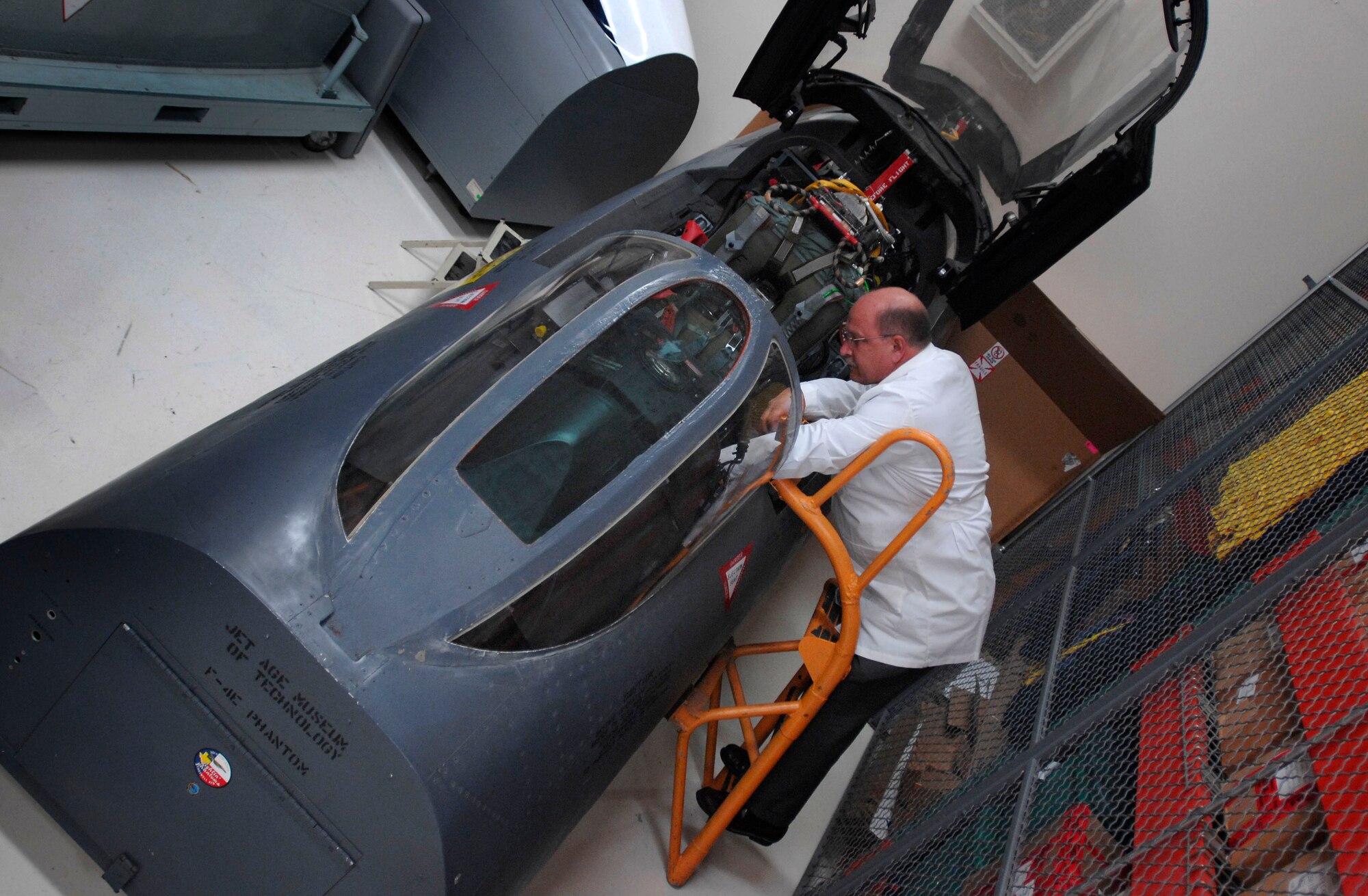 Robert S. Browning III, an equipment analyst at the Life Sciences Equipment Laboratory, looks into the cockpit of an F-4 Phantom II fighter jet. The lab has rebuilt cockpits of a dozen Vietnam War-era aircraft it uses to help make identifications of missing servicemembers. DoD photo by Fred W. Baker III  
 
