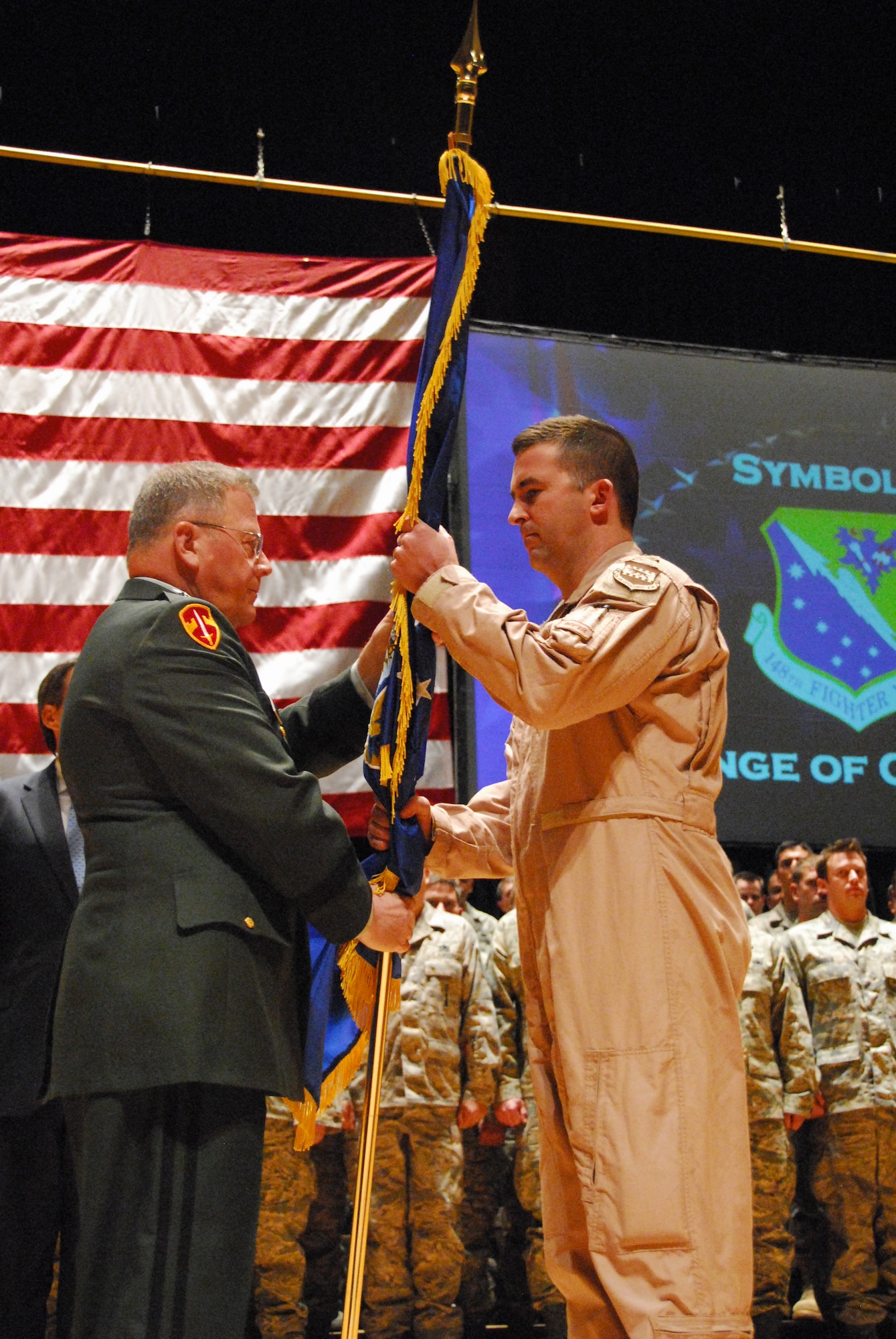 U.S. Army Maj. Gen. Larry Shellito, Adjutant General of the Minnesota National Guard, hands the 148th Fighter Wing's flag to U.S. Air Force Lt. Col. Eric Chandler, 148th Fighter Wing pilot, signifying a change in command for the deploying airmen of the wing during a deployment ceremony in Duluth, Minn. Nov. 2, 2008.  Approximately 300 148th Fighter Wing members will deploy overseas in support of Operation Iraqi Freedom and/or Operation Enduring Freedom between Sept 2008 and Jan 2009. (U.S. Air Force photo by TSgt Amie Dahl) (Released)