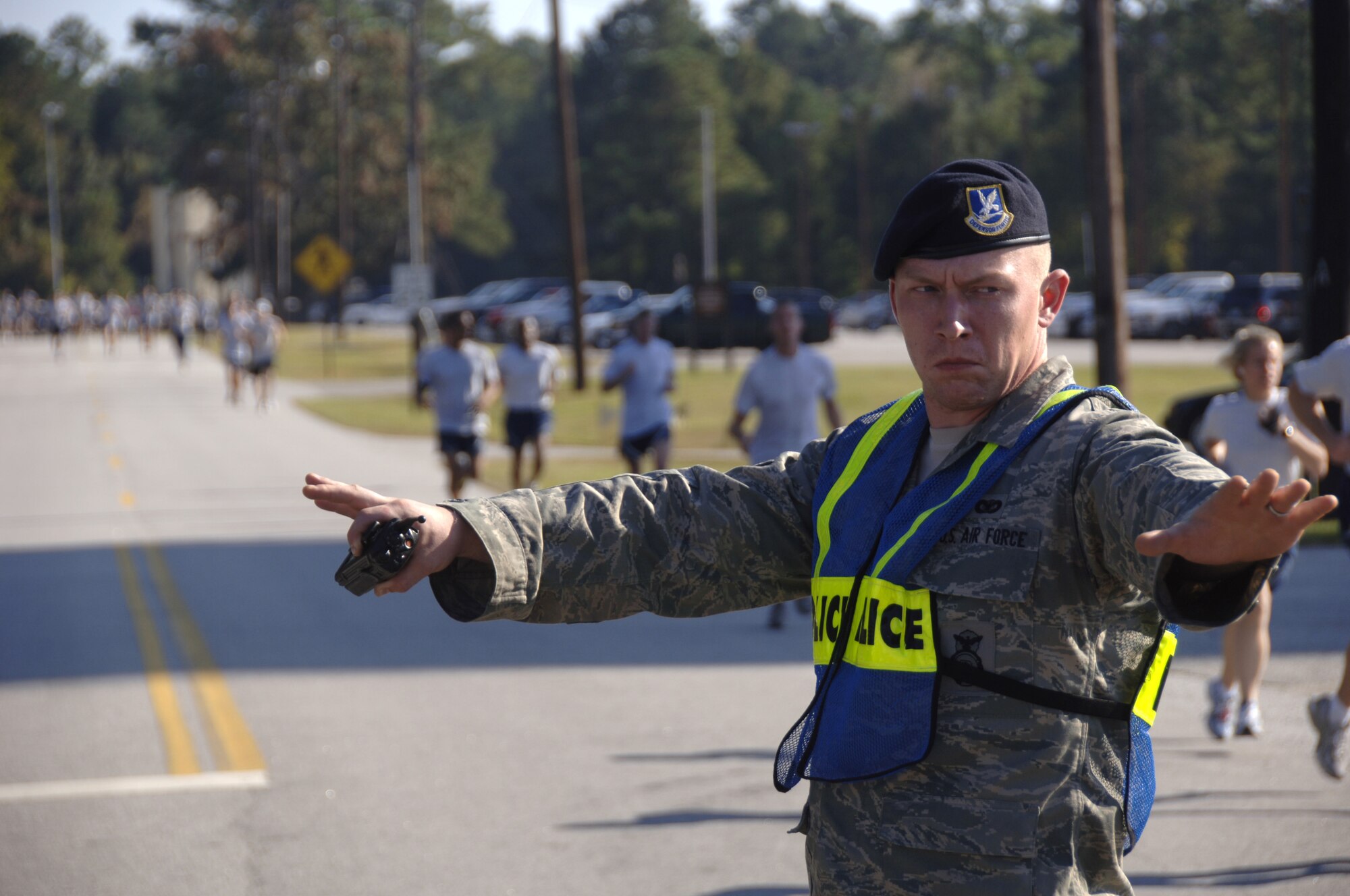 Airman Joshua Long stops traffic to allow Airmen to continue running down Davis Dr. on Charleston AFB Nov. 7. More than 400 Airmen from various squadrons came out to participate in the monthly challenge. Airman Long is assigned to the 437th Security Forces Squadron. (U.S. Air Force photo/Senior Airman Timothy Taylor)