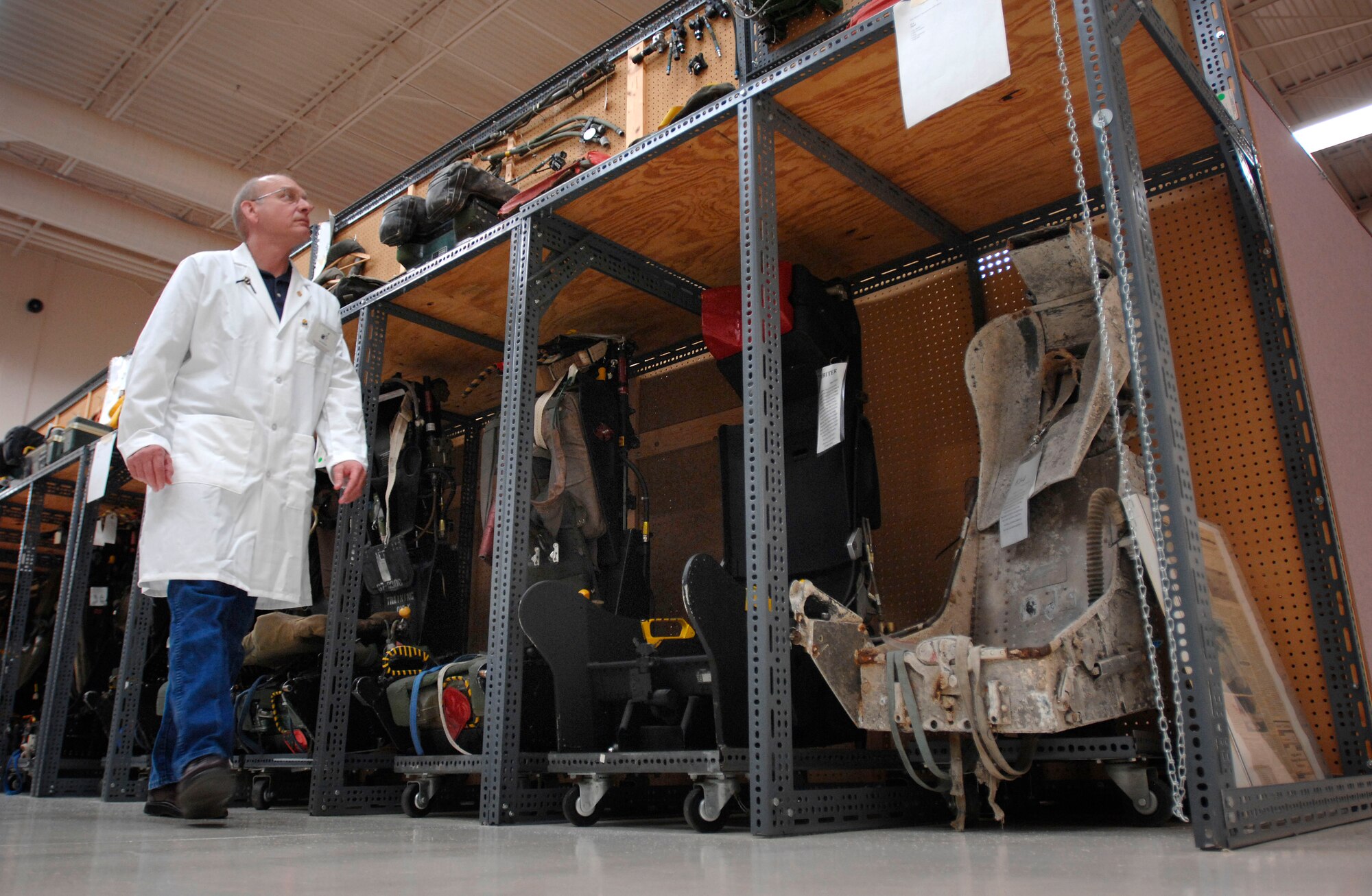 Equipment analyst Jim Hodges walks past rows of ejection seats at the 21,000-square-foot Life Sciences Equipment Laboratory at Brooks City-Base in San Antonio. The lab is home to more than 50,000 uniforms and pieces of equipment from as far back as World War I. About 250 ejection seats line the walls. DoD photo by Fred W. Baker III  

