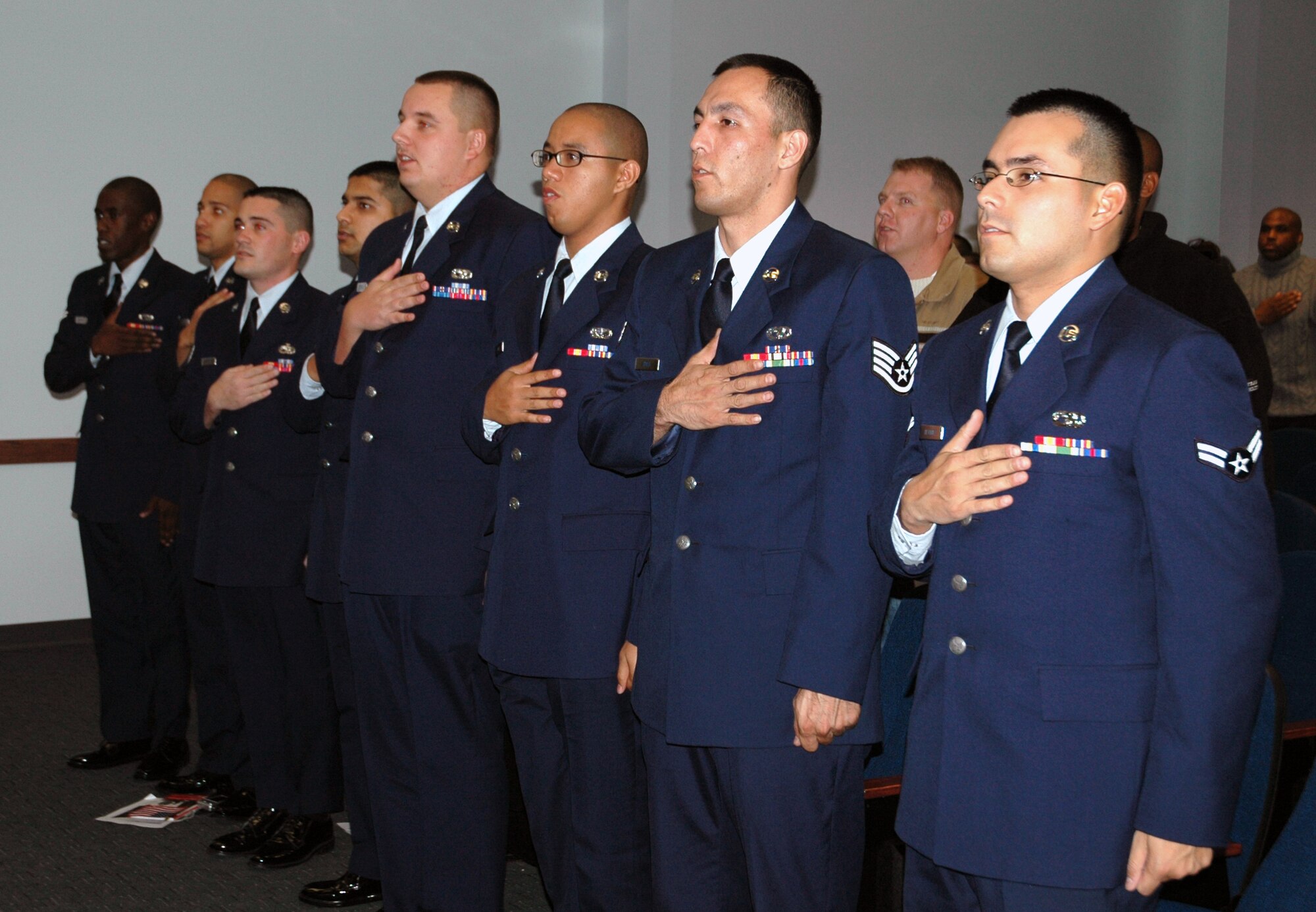 DOVER AIR FORCE BASE, Del. -- Eight 436th Airlift Wing Airmen, who hailed from seven countries, pledge allegiance to the American flag after taking the Oath of Allegiance during the Military Naturalization Ceremony here Nov. 11.(U.S. Air Force photo/Capt. Marnee A.C. Losurdo)
