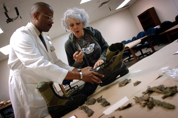 John Goines III, chief of the Life Sciences Equipment Laboratory, shows Sallie Stratton the remains recovered from the crash site of her husband, Air Force Lt. Col. Charles W. Stratton, whose bomber went down Jan. 3, 1971, over Laos. The lab, at Brooks City-Base, Texas, helps the Joint POW/MIA Accounting Command, based in Hawaii, identify service members still missing from past wars. (Department of Defense photo by Fred Baker III)