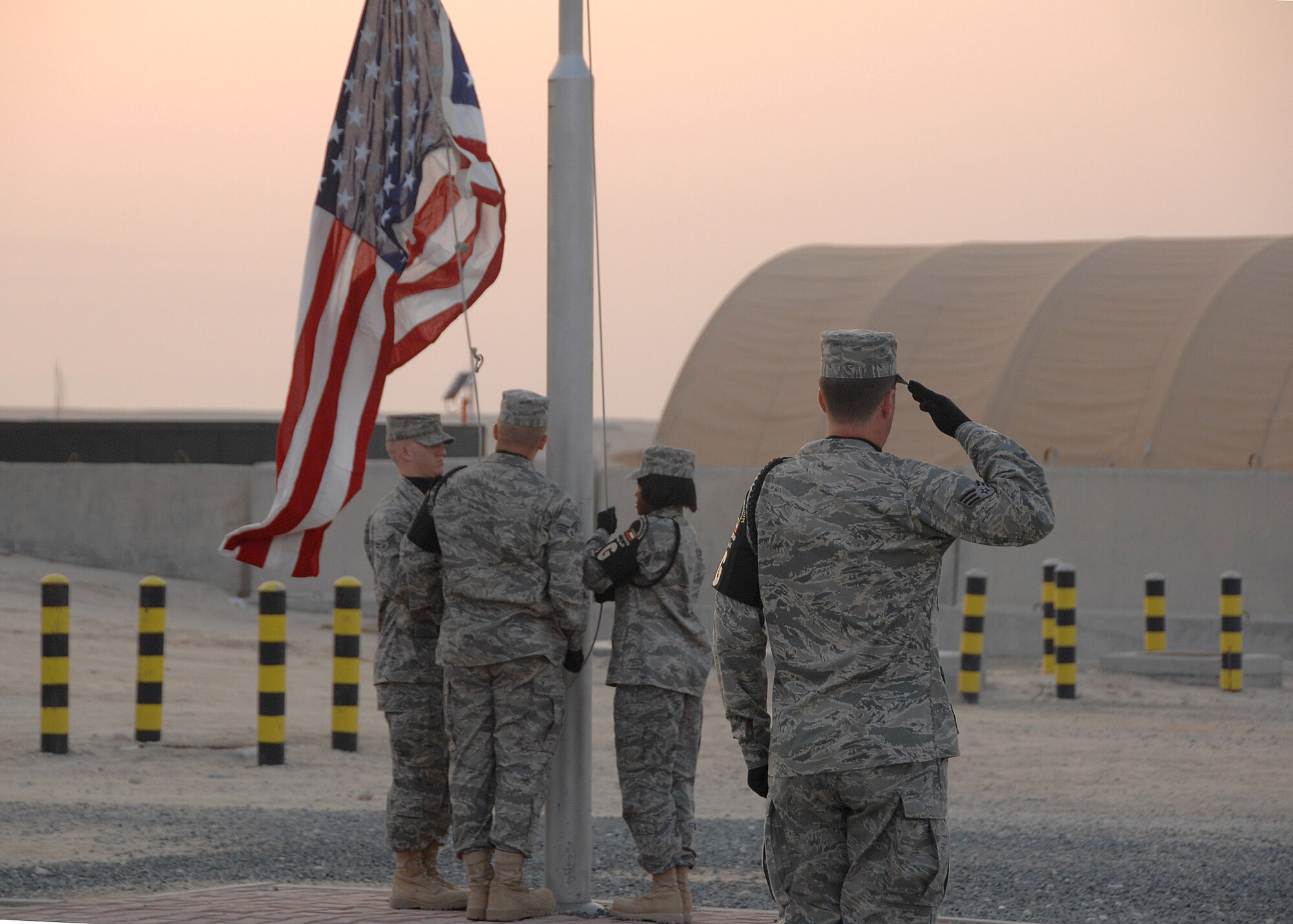 Members of the 386th Air Expeditionary Wing Honor Guard raise the American flag during the Veterans Day Reveille Ceremony Nov. 11 at an air base in Southwest Asia. (U.S. Air Force photo/Tech. Sgt. Raheem Moore) 
