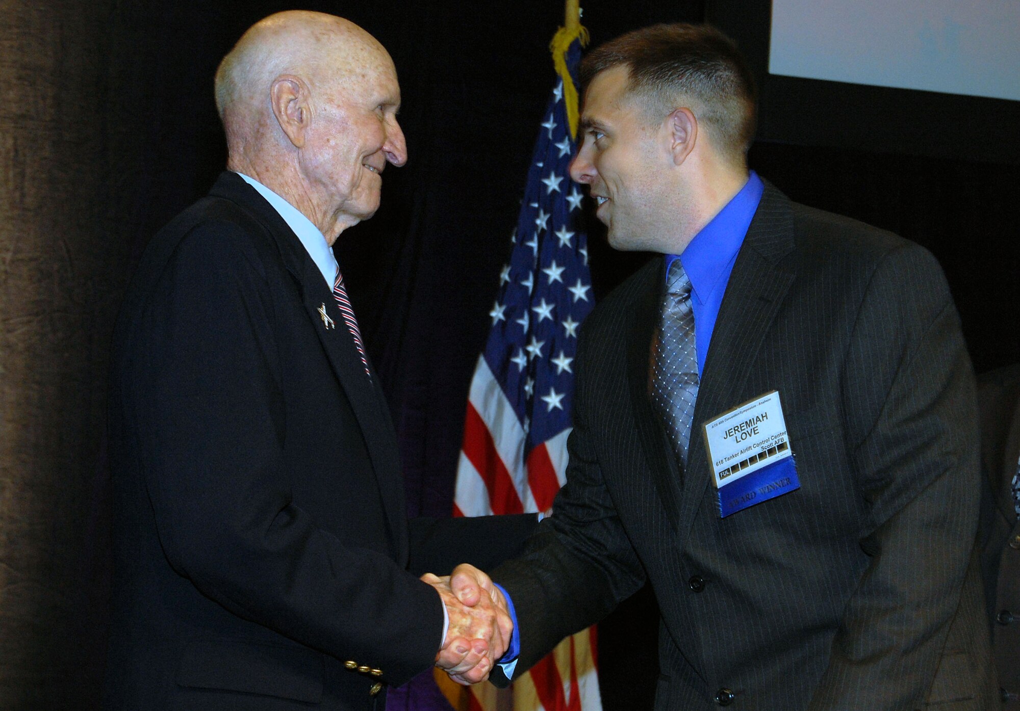 Tech. Sgt. Jeremiah Love, from the 618th Tanker Airlift Control Center at Scott Air Force Base, Ill., and formerly with the 32nd Air Refueling Squadron at McGuire Air Force Base, N.J., shakes hands with retired Col. Gail Halvorsen, also known as the "Candy Bomber," during the banquet for the 2008 Airlift/Tanker Association convention in Anaheim, Calif., Nov. 8.  Sergeant Love was a 2008 A/TA Young Leadership Award winner and is a KC-10 evaluator in-flight refueling operator. Sergeant Love was nominated for his award while he was stationed at McGuire.  (U.S. Air Force Photo/Tech. Sgt. Scott T. Sturkol)