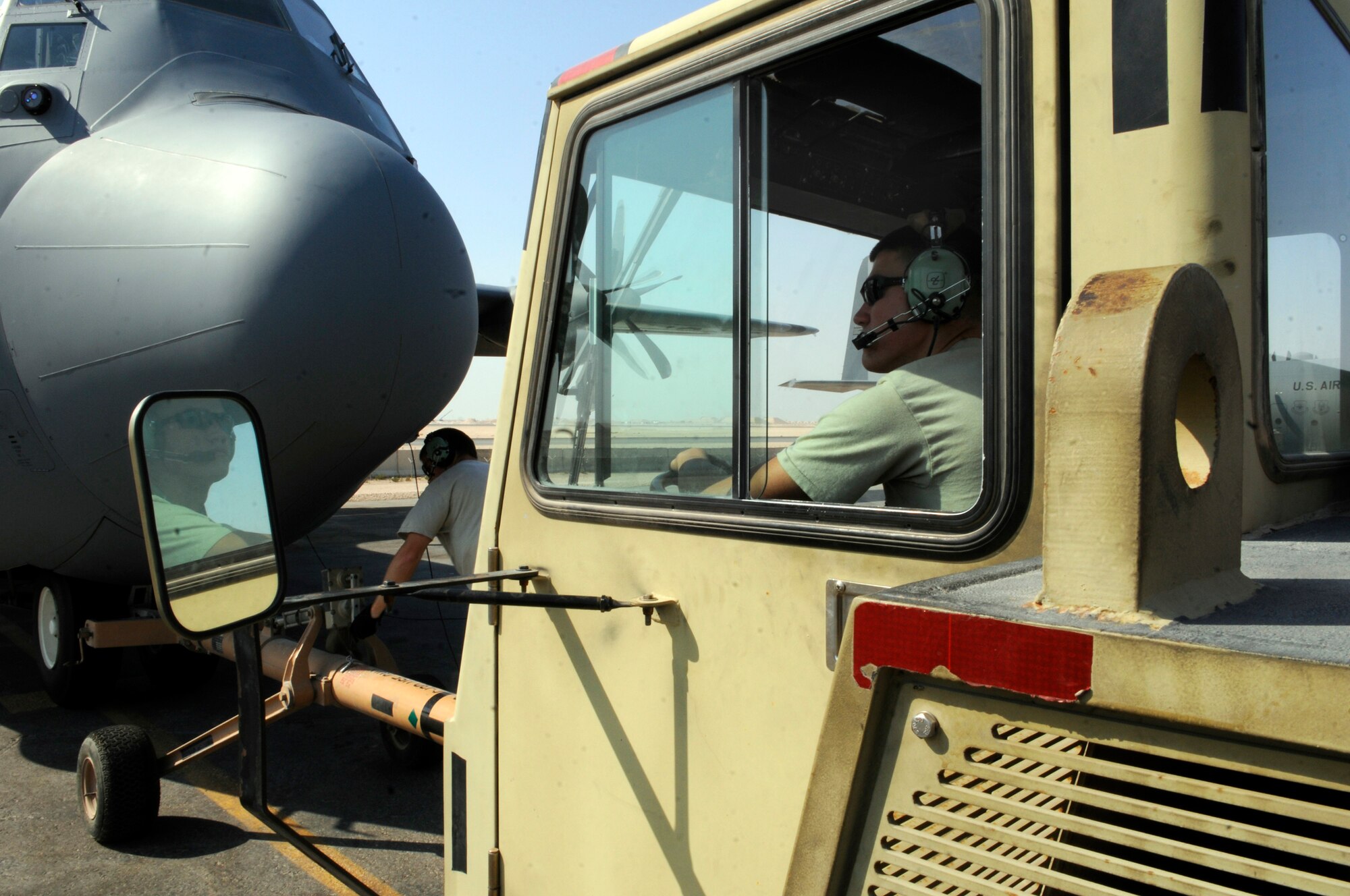 Airman 1st Class Joseph Marion, crew chief assigned to the 379th Expeditionary Aircraft Maintenance Squadron, holds position in a tow vehicle, while Staff Sgt. Gordon Grgurich, also a crew chief with the 379 EAMXS, lowers the wheels on the tow bar prior to disconnecting it from a C-130 Hercules, Nov.11, at an undisclosed air base in Southwest Asia.  C-130s are capable of operating from rough, dirt strips and are the prime transport for air dropping troops and equipment into hostile areas within the Central Command area of responsibility.  Sergeant Grgurich is a native of Saint Clair, Mo., and Airman Marion hails from Port Richey, Fla.  Both are deployed from Little Rock, Air Force Base, Fla., in support of Operations Iraqi and Enduring Freedom and Joint Task Force-Horn of Africa.  (U.S. Air Force photo by Tech. Sgt. Michael Boquette/Released)