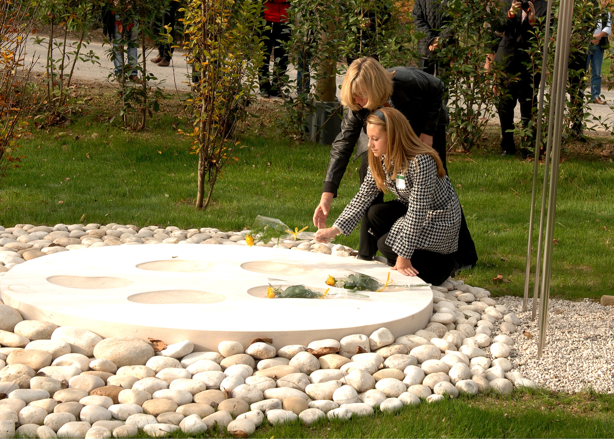 Family members place a single yellow rose on the UH-60 Helicopter Crash Memorial in remembrance of those military members who lost their lives during the Nov. 8, 2007 crash in Santa Lucia di Piave, Italy. Members of the Aviano Air Base and Santa Lucia di Piave communities gathered to honor both those vicitms of the crash and the thousands of Italians who lost their lives in the Piave River during World War I during a special ceremony on Nov. 8.  (U.S. Air Force photo/Senior Airman Taylor Marr)