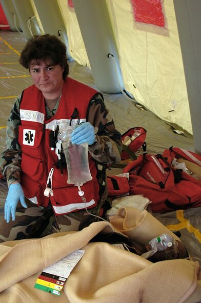 MISAWA AIR BASE, Japan -- Petty Officer 1st Class Lisa Hovde, Naval Air Facility Misawa, holds an intravenous drip bag over simulated patient Staff Sgt. Jasma Jones, during an aircraft mishap exercise held at nearby Misawa Airport, Nov. 6, 2008. The annual exercise involved fire and medical personnel from the Air Force, Navy, Japan Air Self-Defense Force, and Misawa City emergency first responders. (U.S. Navy photo by Chief Petty Officer Brian Naranjo)