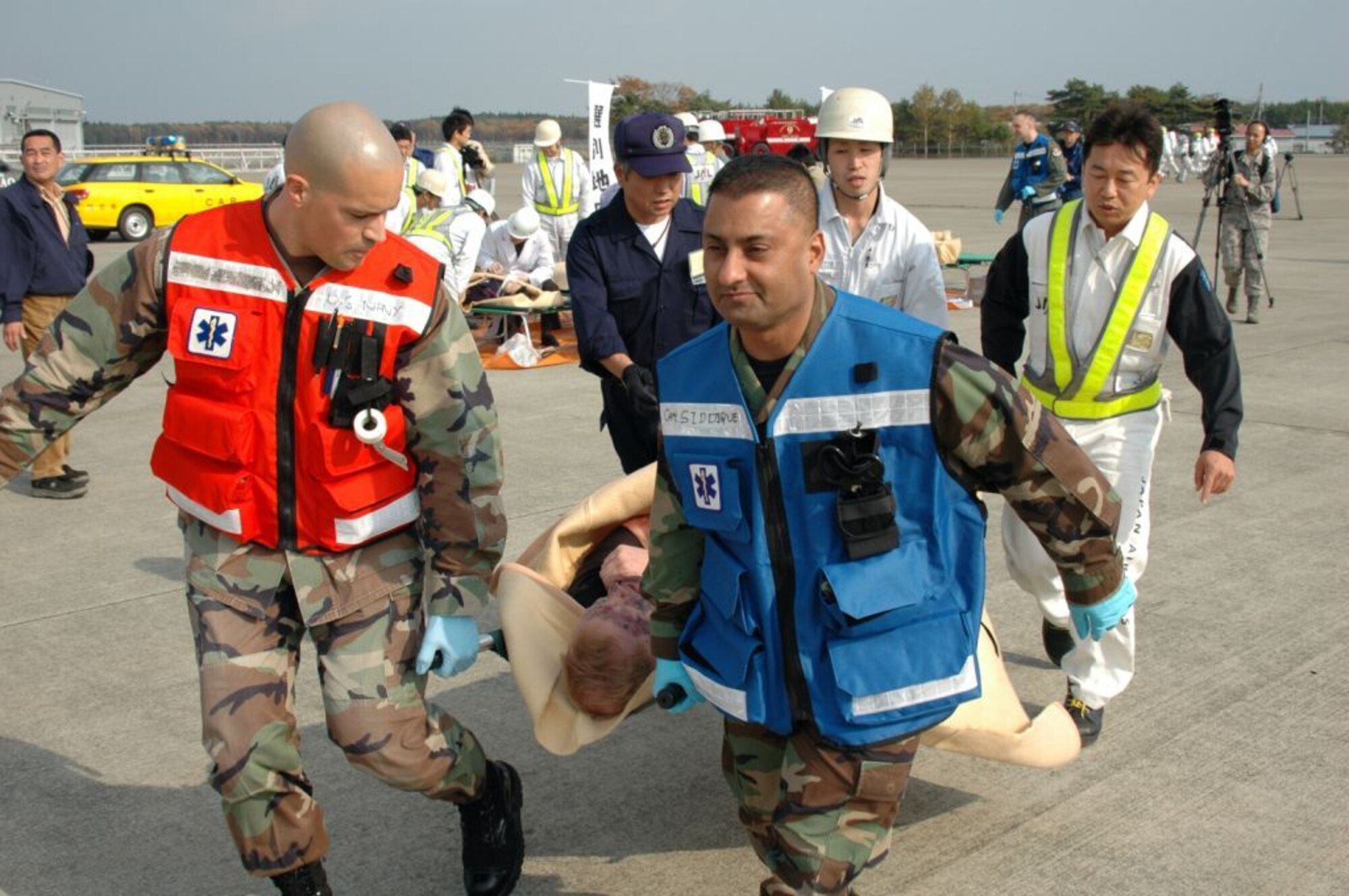 MISAWA AIR BASE, Japan -- Petty Officer 2nd Class Orlando Garcia, Naval Air Facility Misawa, and Capt. Zahid Siddique, 35th Medical Group, move a victim to a treatment tent, during an aircraft mishap exercise held at nearby Misawa Airport Nov. 6, 2008. The annual exercise involved fire and medical personnel from the Air Force, Navy, Japan Air Self-Defense Force, and emergency first responders from the local Japanese area. (U.S. Navy photo by Chief Petty Officer Brian Naranjo)
