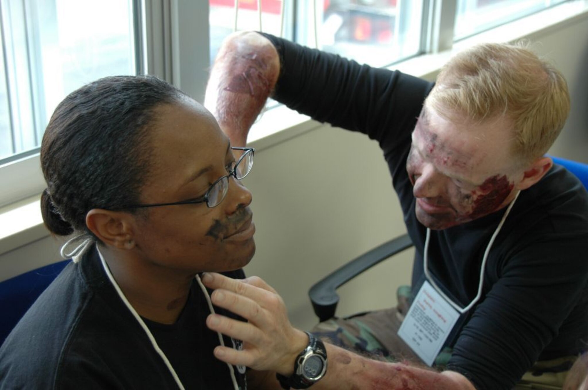 MISAWA AIR BASE, Japan -- Tech. Sgt. Brian Brantley, 35th Medical Group, touches up the moulage make-up of Staff Sgt. Jasma Jones. Both Sergeant Jones and Sergeant Brantley played the roles of burn victims during an aircraft mishap exercise held at nearby Misawa Airport Nov. 6, 2008. The annual exercise involved fire and medical personnel from the Air Force, Navy, Japan Air Self-Defense Force, and emergency first responders from the local Japanese community. (U.S. Navy photo by Chief Petty Officer Brian Naranjo)