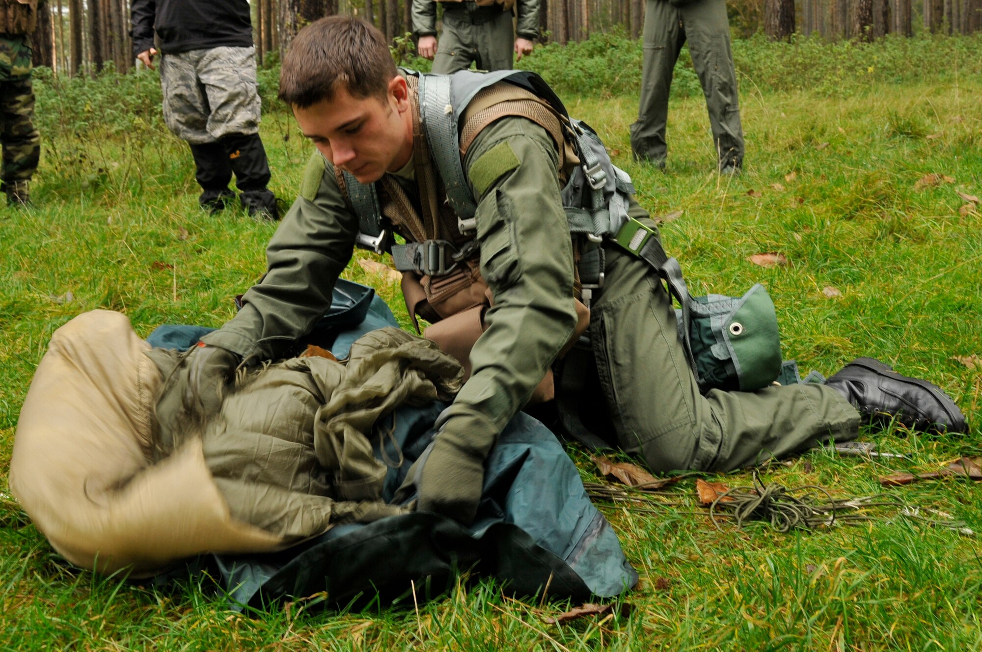 Staff Sgt. Sean Marlow, 48th Operational Support Squadron wing SERE specialist, quickly packs his parachute so he can move to a concealed location Nov. 11 at Stanford Training Area in Thetford, England. Survival, evasion, resistance and escape (SERE) instructors performed a refresher course for future deployers. (U.S. Air Force photo by Airman 1st Class Perry Aston)