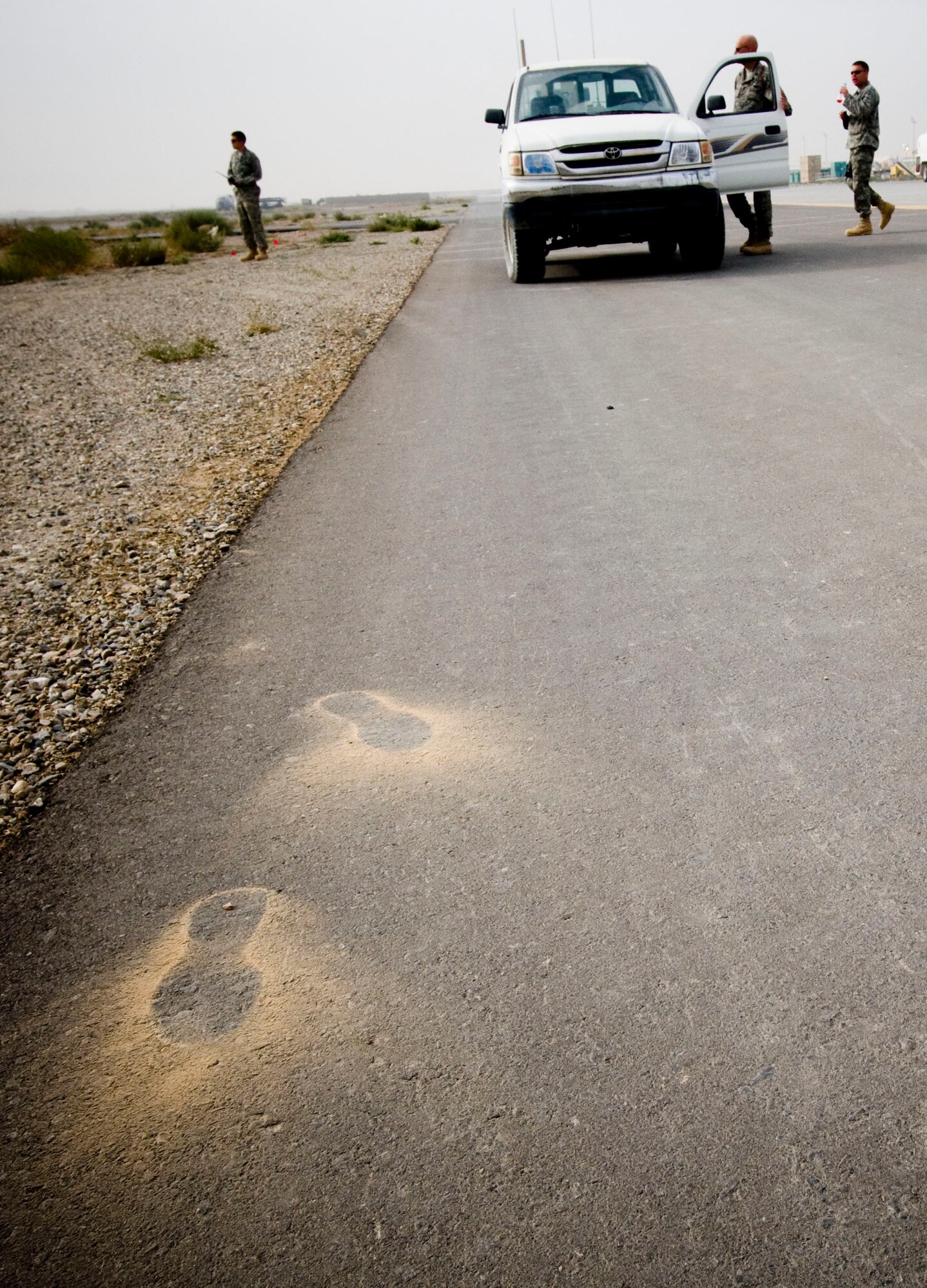 Dusty footprints betray the exit of Airmen involved with the controlled burn at Bagram Air Field, Afghanistan, Nov. 7. The soft, dusty sand in Afghanistan forced the Explosive Ordinance Disposal team to take extra care to not disturb the bomb, but in the end, the operation was a success, keeping to the schedule right down to the minute. (U.S. Air Force photo by Staff Sgt. Samuel Morse/Released)