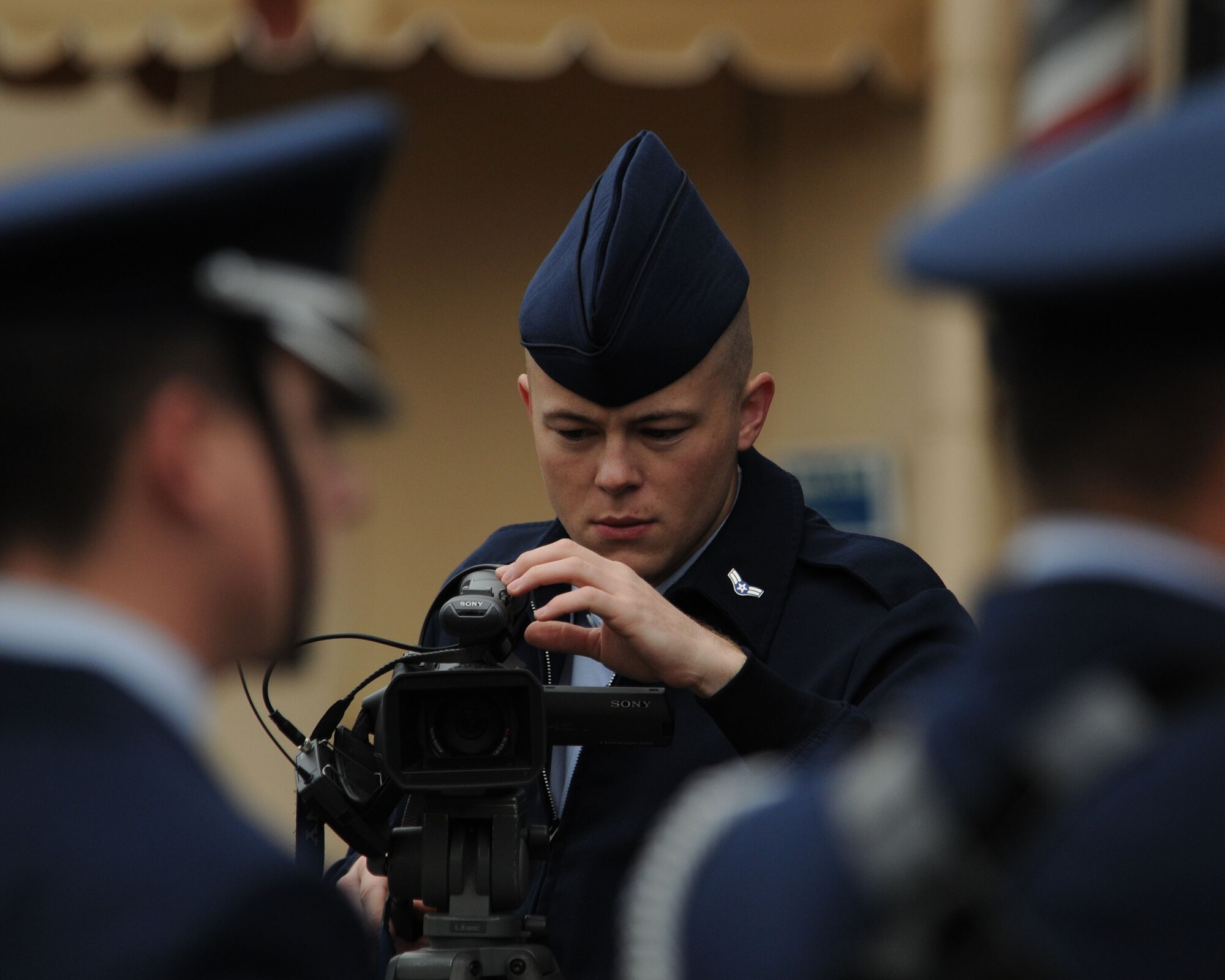 YOKOTA AIR BASE, Japan -- Airman 1st Class Paul Sims films the honor guard during one of two Veterans Day ceremonies held here Nov. 11.  The Yokota Air Base Honor Gurad posted the colors and provided a five-gun salute in honor of U.S. veterans. Airman Sims is assigned to 374th Airlift Wing Public Affairs. (U.S. Air Force photo by Senior Airman Brian Kimball)
