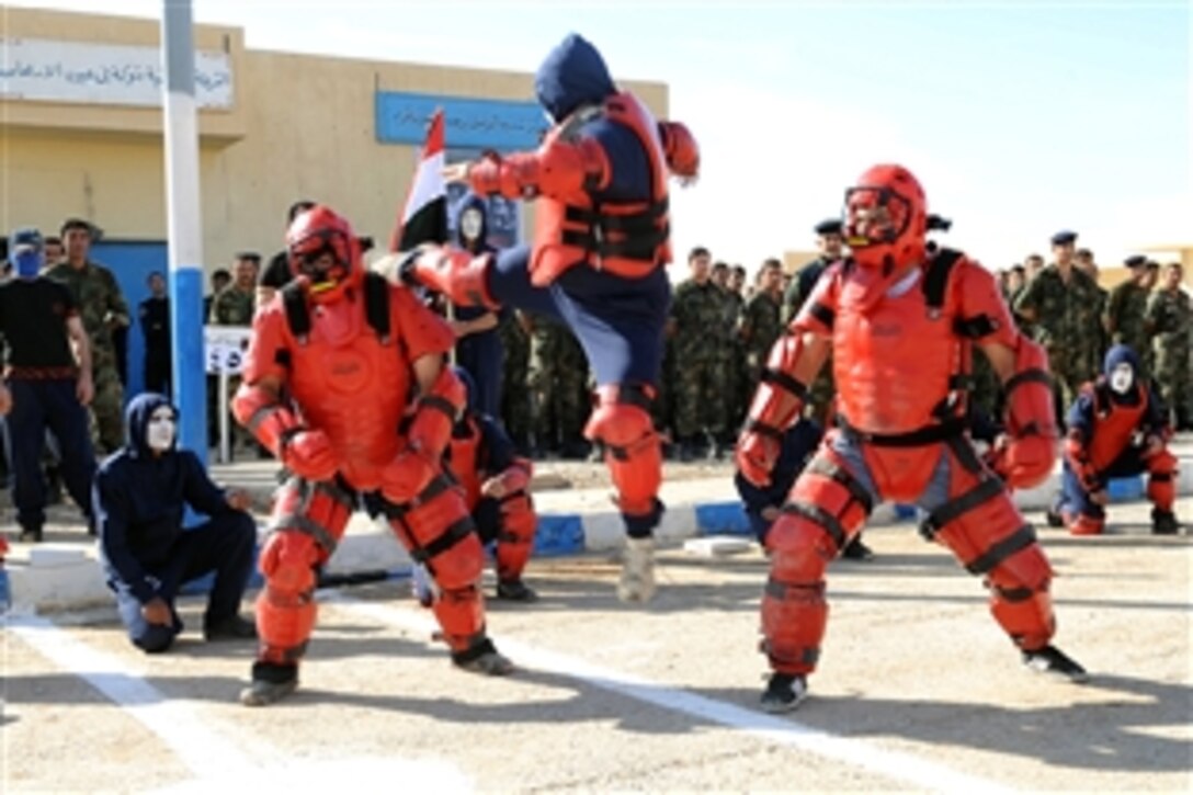 Iraqi police officers perform martial arts kicks and moves taught to them by Coalition Forces during the Mosul Police Security Academy graduation, Mosul, Iraq, Nov. 9, 2008. 